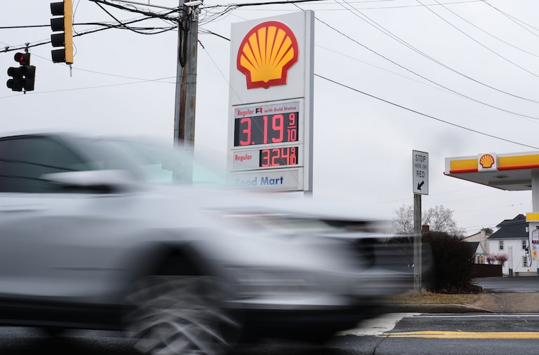Fuel prices are displayed at a gas station as cars drive by in Baltimore.