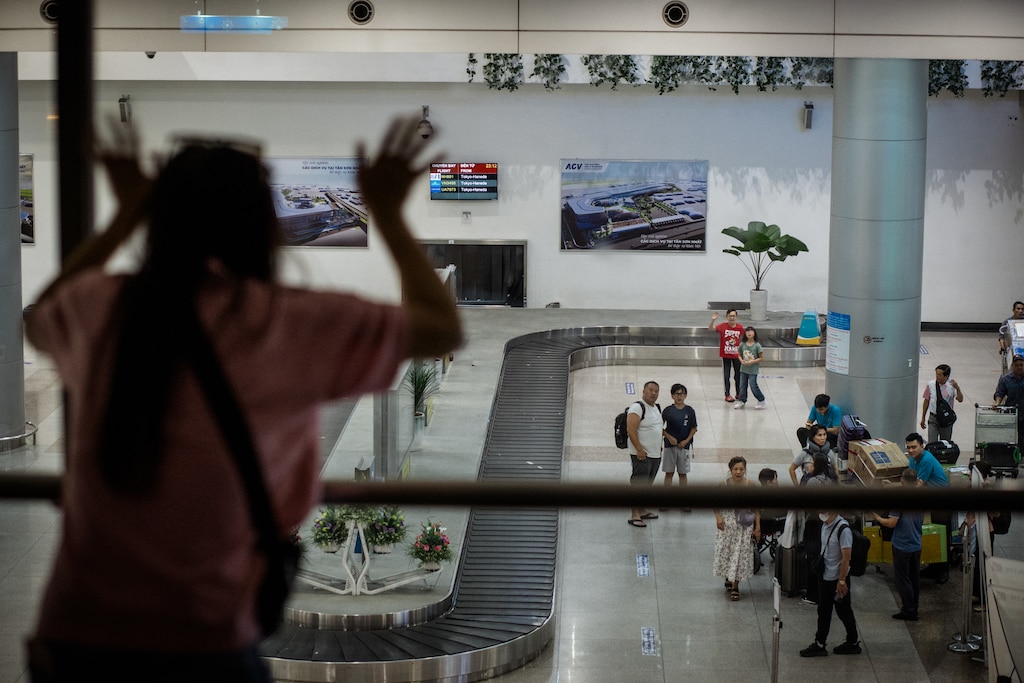Ho Chi Minh, Vietnam - July 27, 2026: Melissa Tran, 44, waves to her children, Jacob and Riley at the baggage area at Tan Son Nhat International Airport in Ho Chi Minh, Vietnam on July 27, 2026. Rosem Morton for The Baltimore Banner