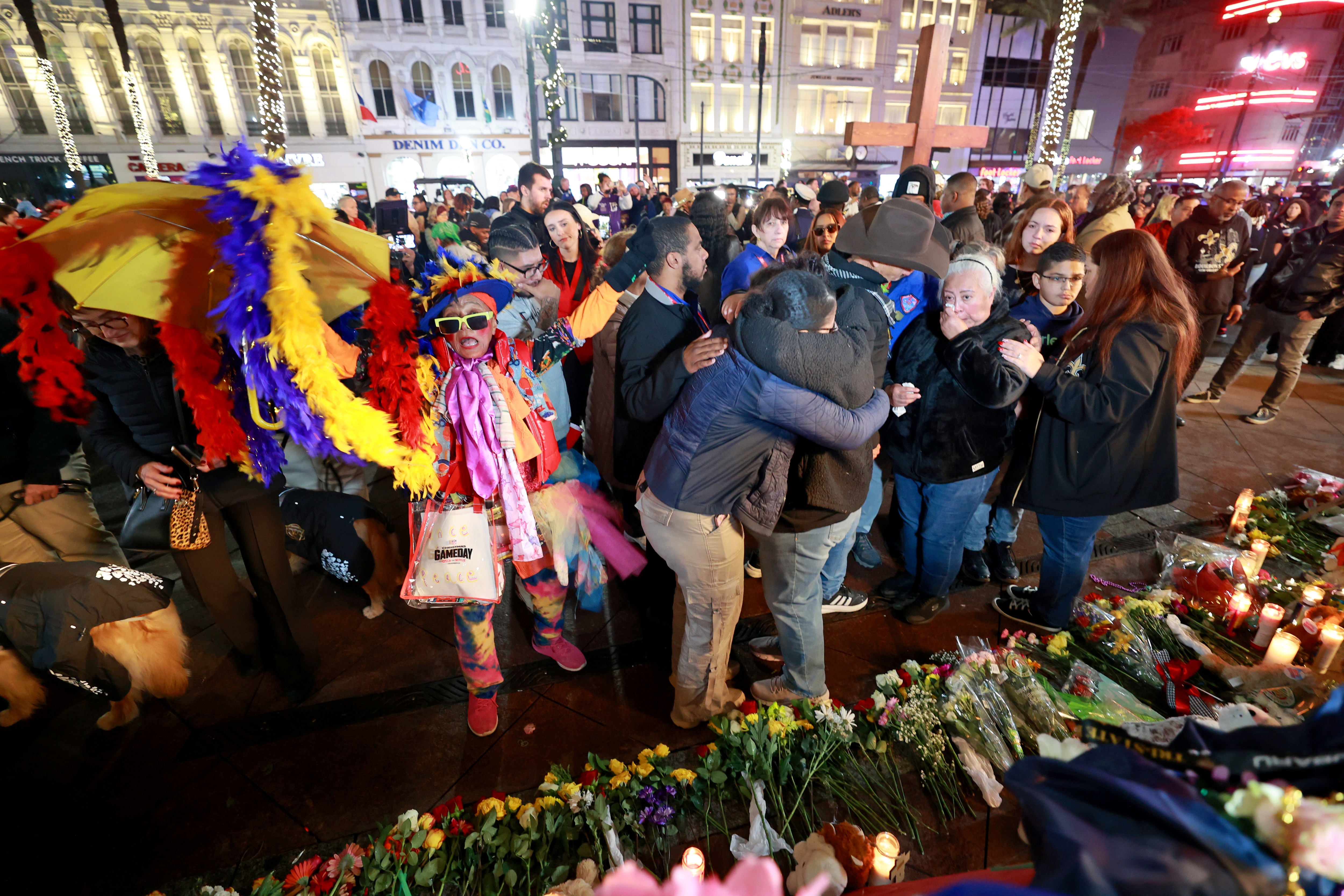 NEW ORLEANS, LOUISIANA - JANUARY 4: The family of Bourbon Street terror attack victim Nicole Perez console one another as Jennifer Jones (L) dances to a brass band during a vigil on Canal Street near Bourbon Street on January 4, 2025 in New Orleans, Louisiana. Fourteen people were killed and over 30 were injured when a driver intentionally drove into a crowd on Bourbon Street in the early morning hours of New Year's Day in what police are calling a terrorist attack. (Photo by Michael DeMocker/Getty Images)