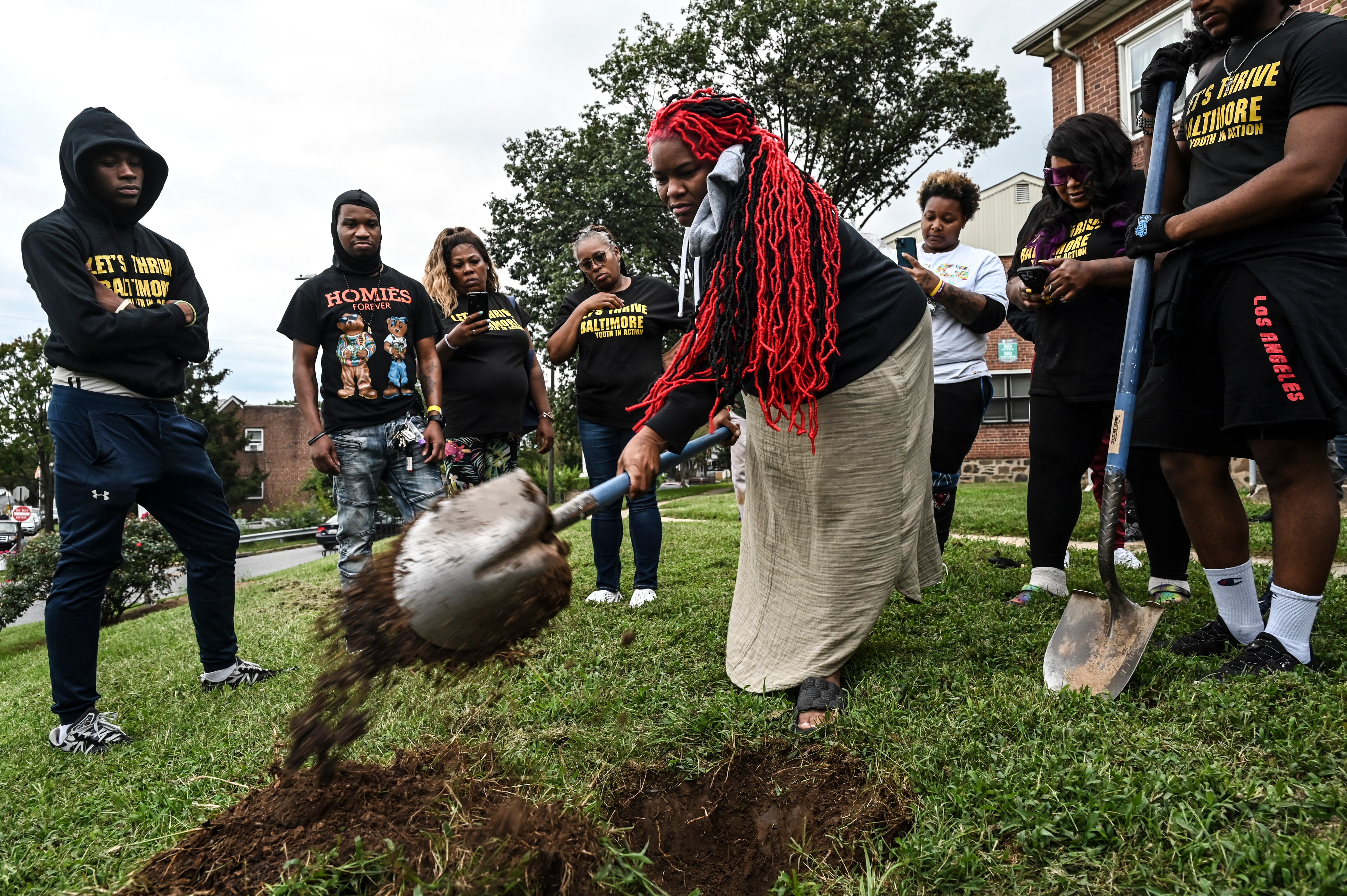 Tameka Lynbrith, mother of Kylis Fagbemi, who was killed in the Brooklyn Homes shooting in July, digs the hole for her son's memorial tree at the Brooklyn Healing Day event on Saturday