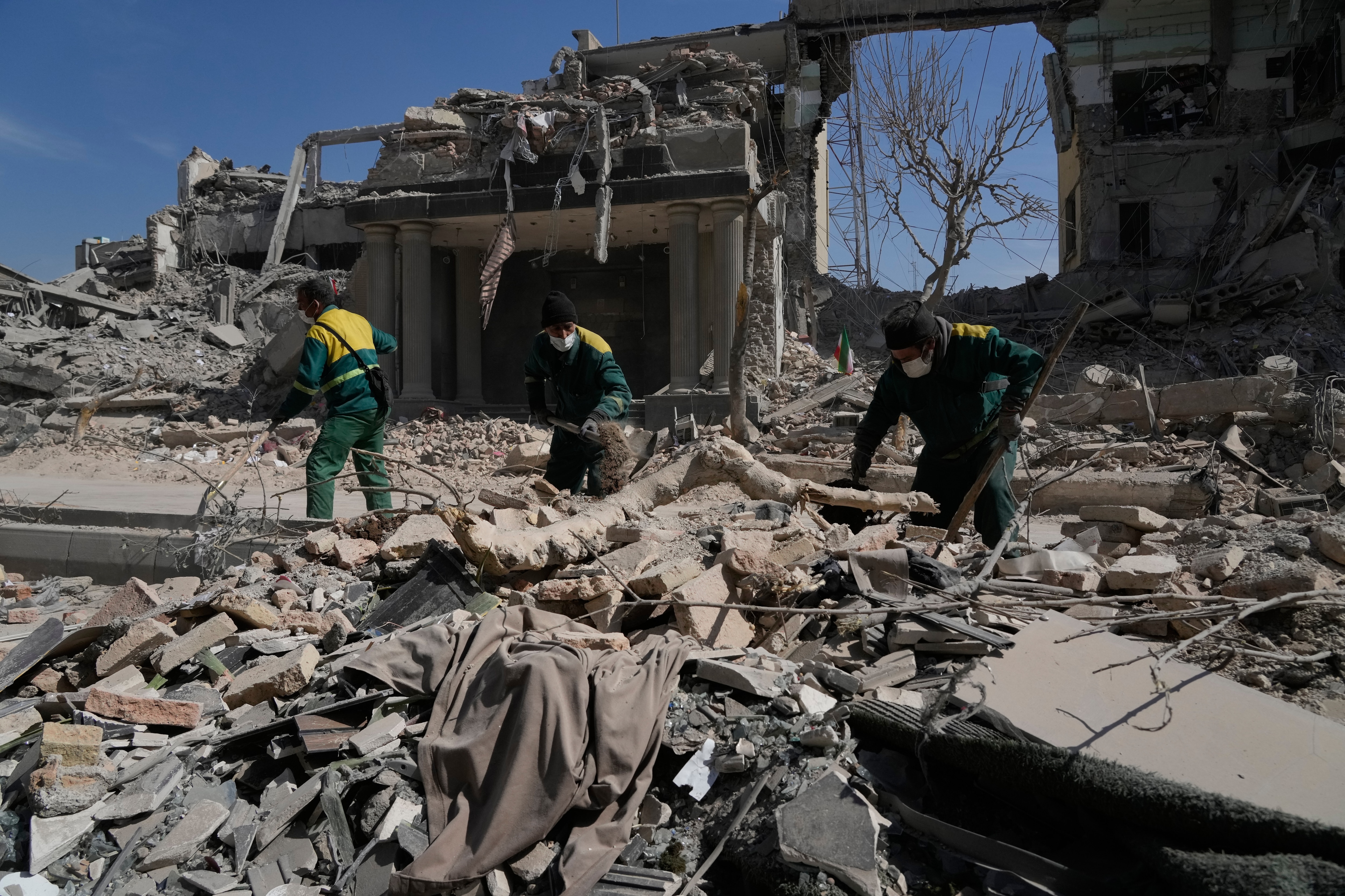 Workers remove the rubble of a police facility struck during the U.S.–Israeli military campaign in Tehran.