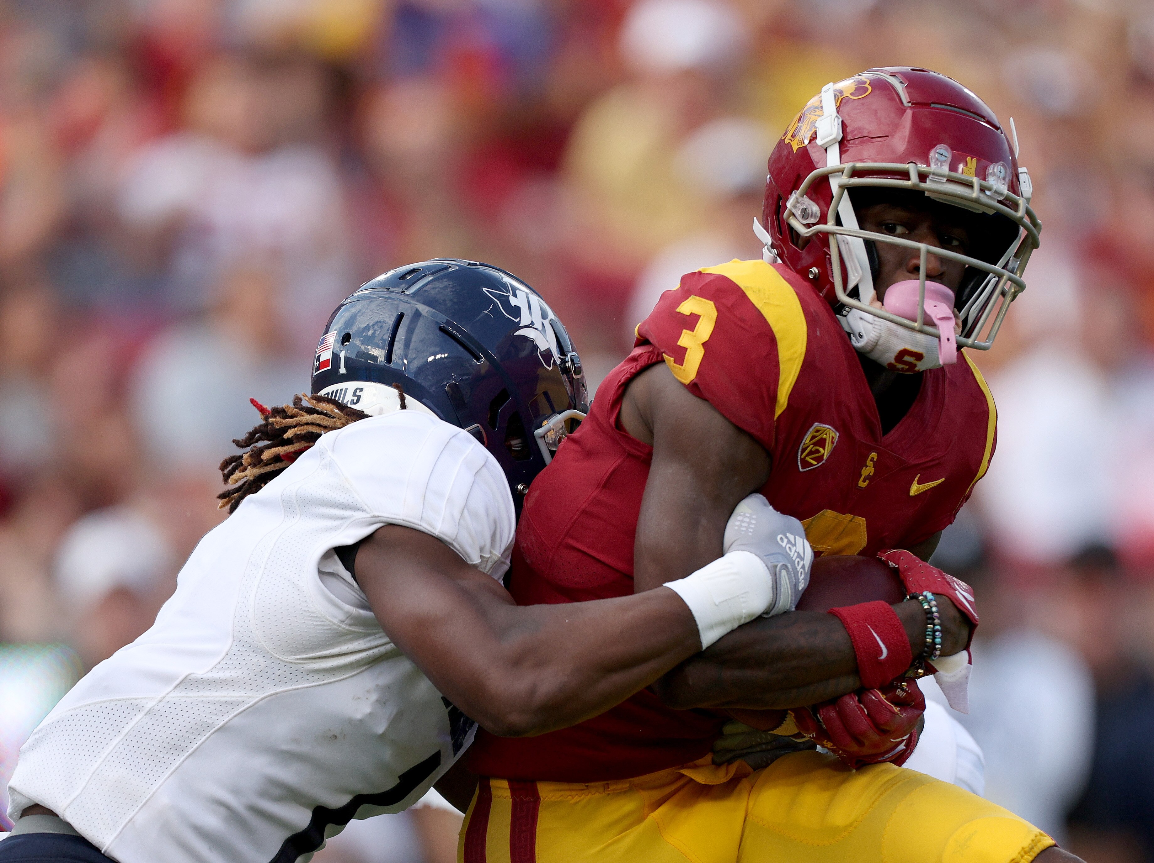 LOS ANGELES, CALIFORNIA - SEPTEMBER 03: Jordan Addison #3 of the USC Trojans is tackled by Sean Fresch #1 of the Rice Owls after his catch during a 66-14 Trojans win over the Rice Owls at United Airlines Field at the Los Angeles Memorial Coliseum on September 03, 2022 in Los Angeles, California.