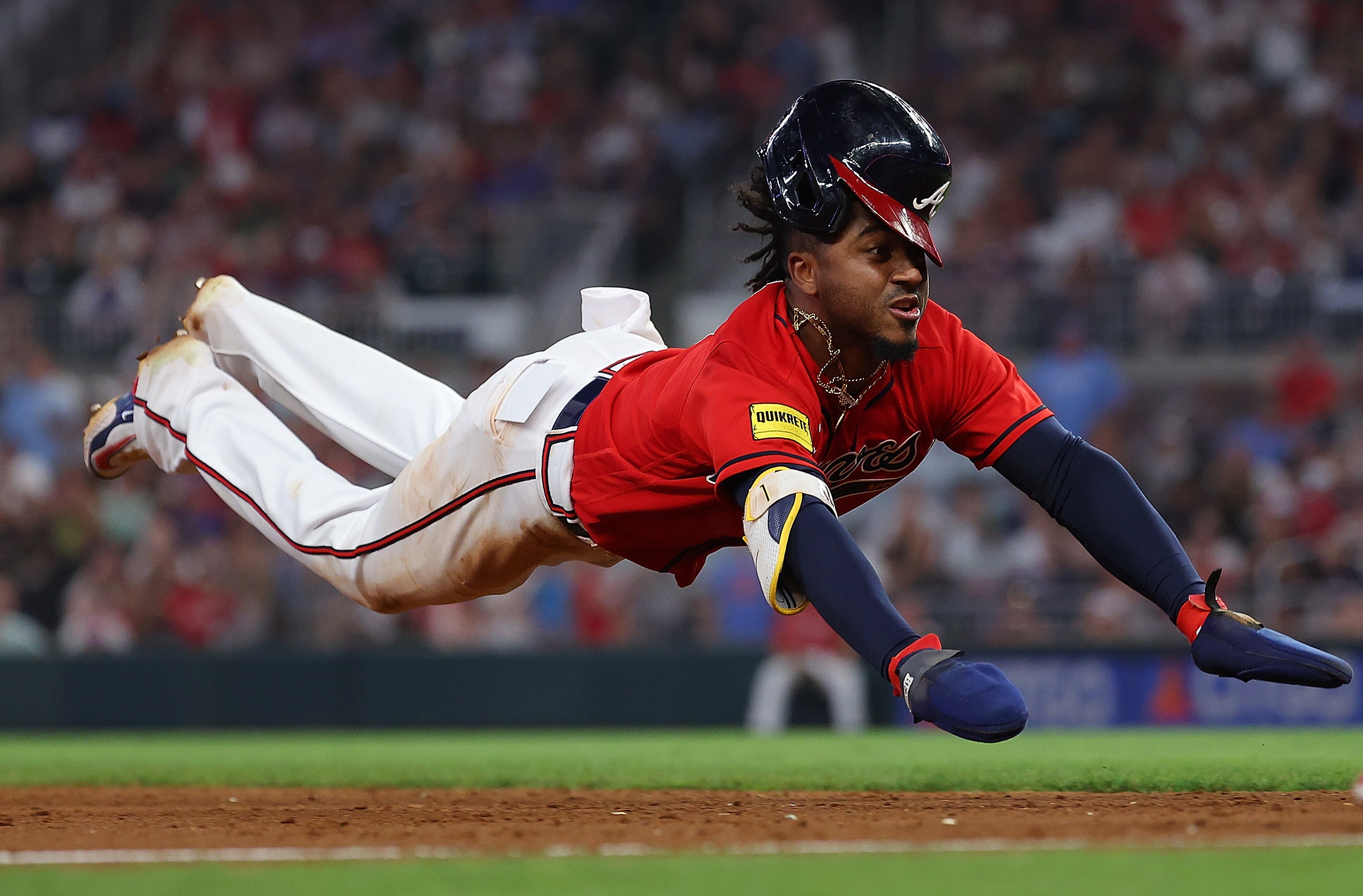 Ozzie Albies of the Braves dives into third base during the sixth inning of Atlanta's 3-2 win over the Nationals.