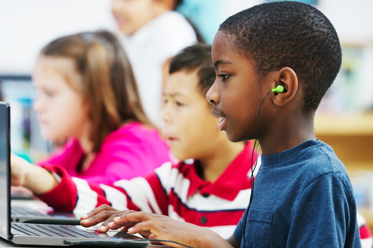 A little boy takes a standardized test on a laptop.