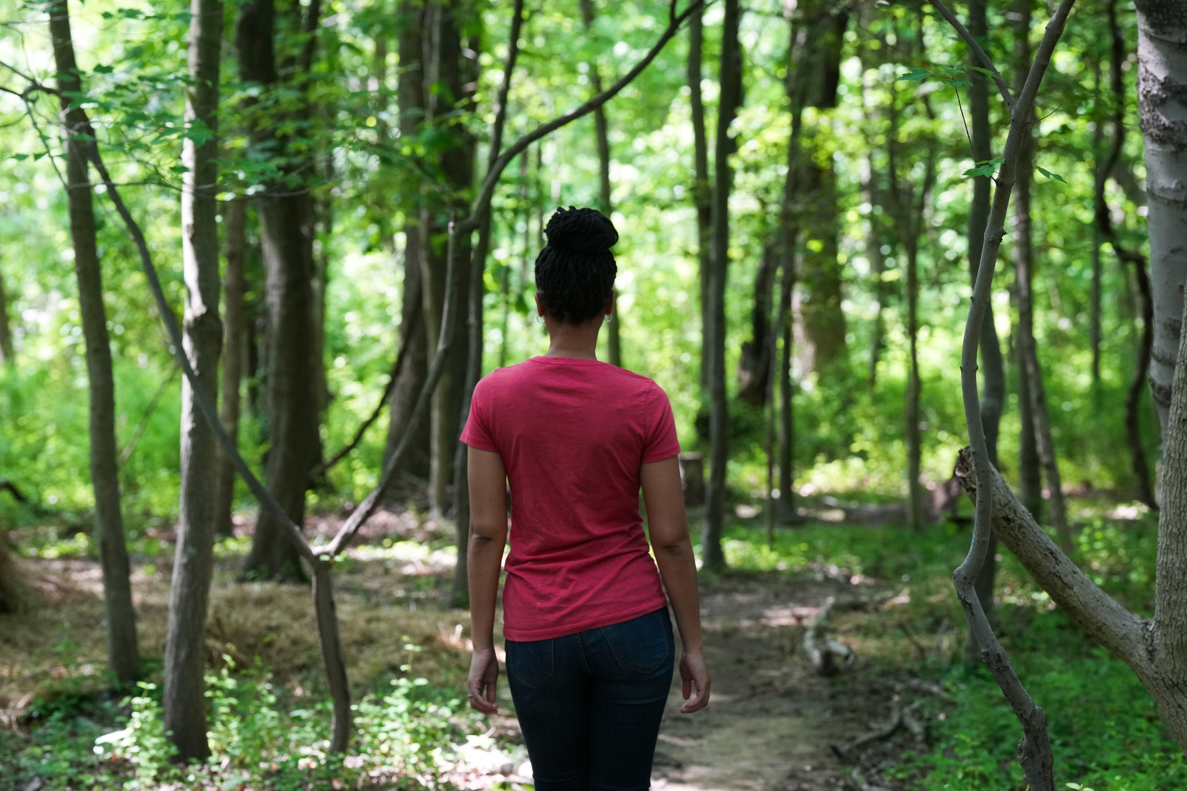 Atiya Wells, manager of the park and trails at Backyard Basecamp, stands among trees many of which have fallen down, on May 11, 2023.