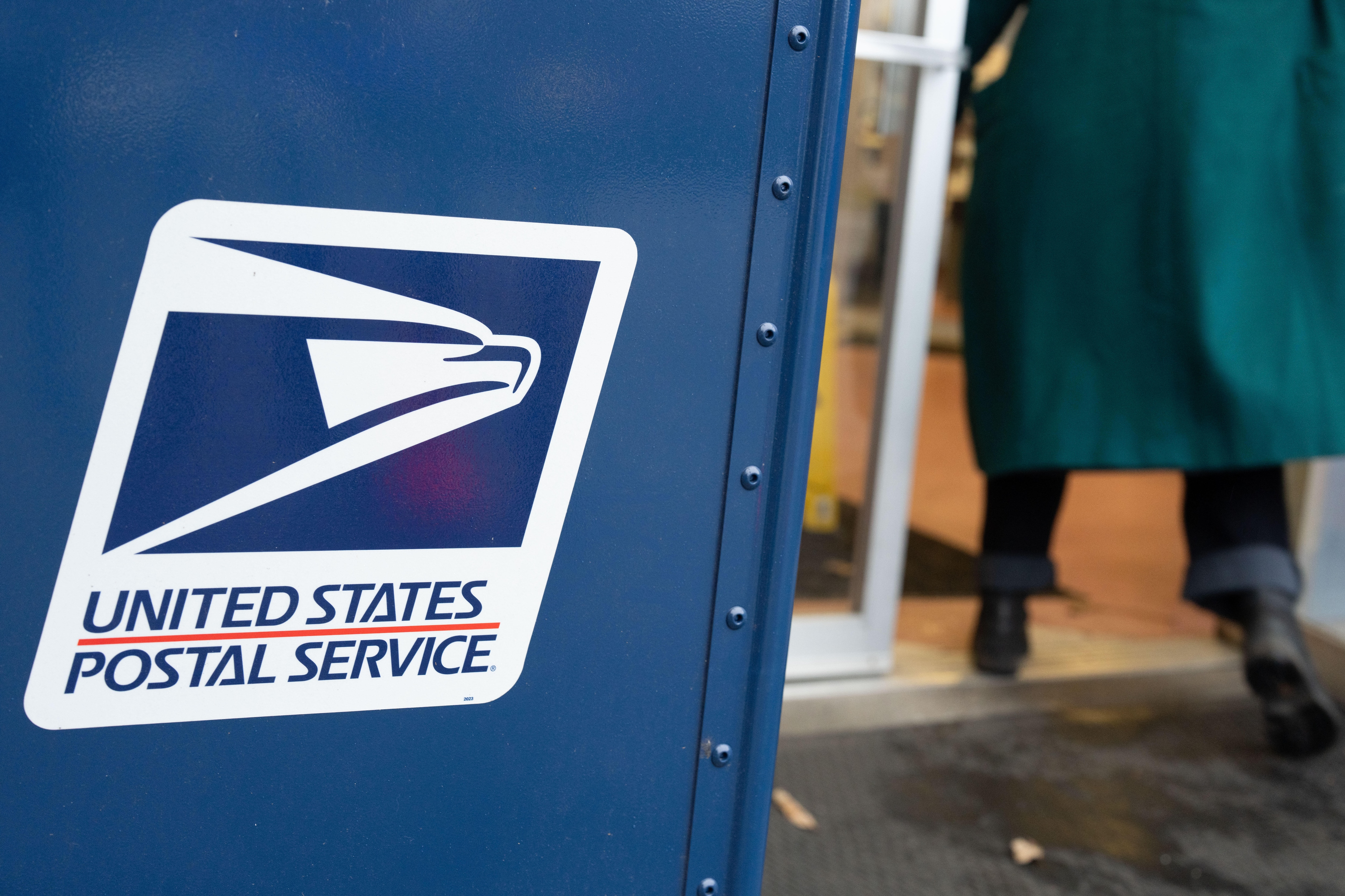 A United States Postal Service mail collection box is seen as a person walks in to the USPS building on Tuesday, Jan. 6, 2026, in Portland, Ore. (AP Photo/Jenny Kane)