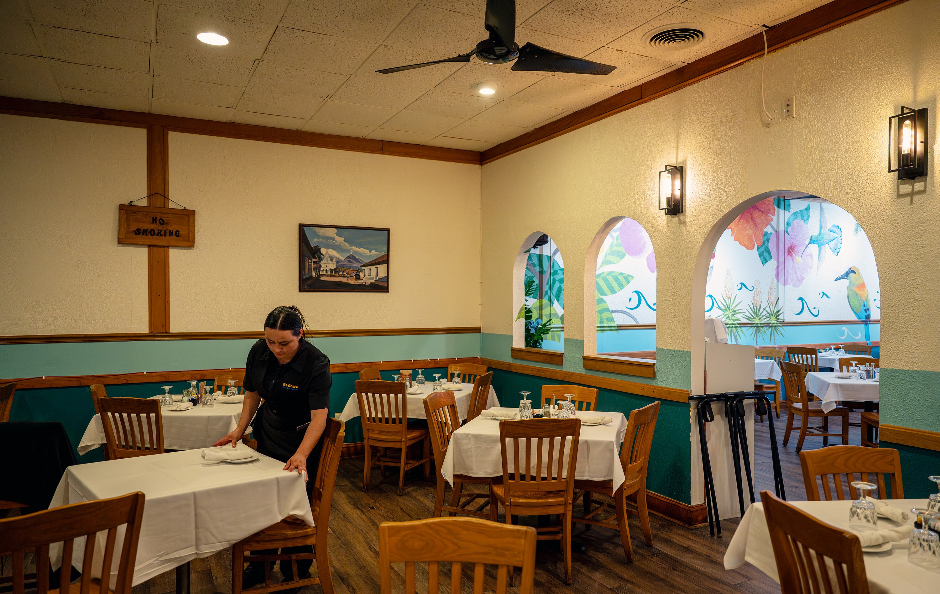 Server Brenda Ramirez cleans and resets tables after lunch service at El Golfo Restaurant in Silver Spring on Friday.