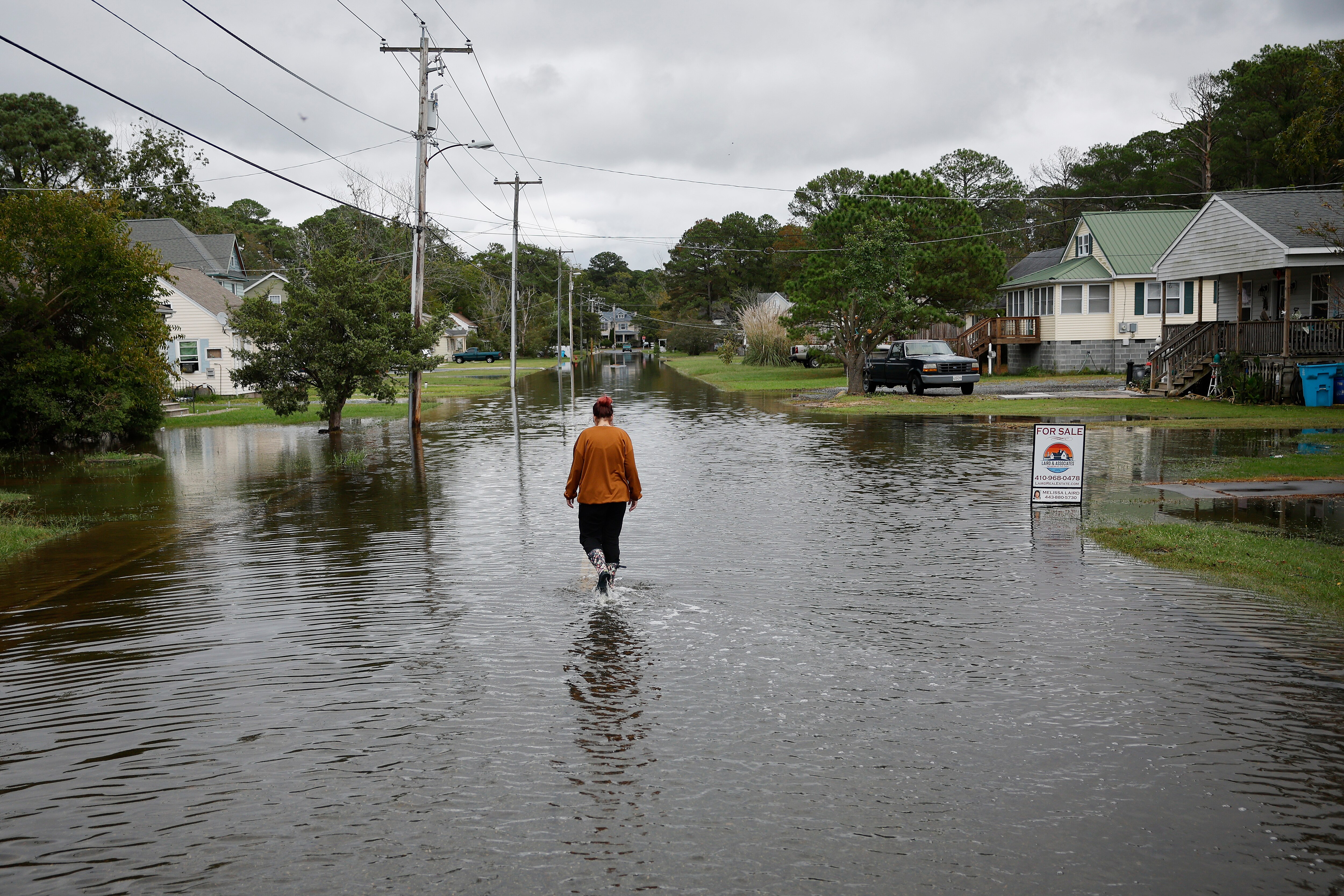CRISFIELD, MD - SEPTEMBER 24: A home health aide walks to her client's home along the flooded Cove Street following two days of heavy rain from Tropical Storm Ophelia on September 24, 2023 in Crisfield, Maryland. Ophelia made landfall early Saturday in North Carolina, producing high winds and heavy rain across the Carolinas, Virginia, Maryland, Delaware, and New Jersey. The city of Crisfield will apply for Federal Emergency Management Agency and Maryland Department of Emergency Management grants to help pay for a $63 million flood control program to mitigate flooding by raising roads, and building new tide gates, berms, and other projects.