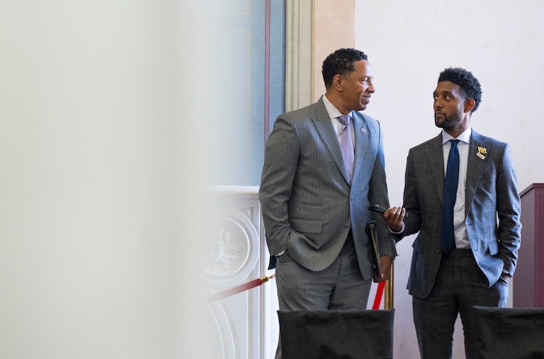 Baltimore City State's Attorney Ivan Bates and Mayor Brandon Scott chat on October 17, 2024 before sitting on a panel discussion about gun violence at the historic Clifton Mansion.