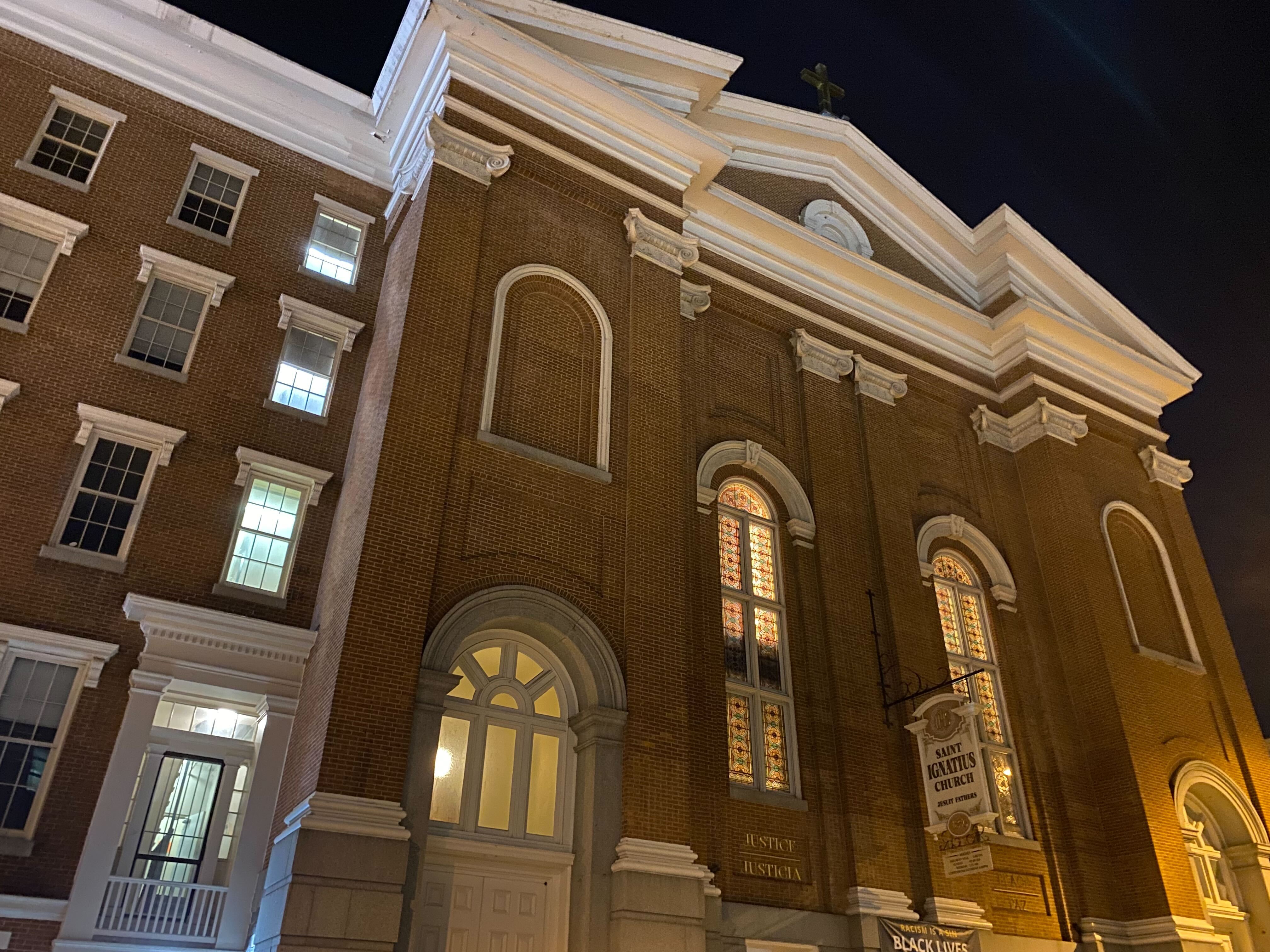 A brick Catholic church in an urban setting.