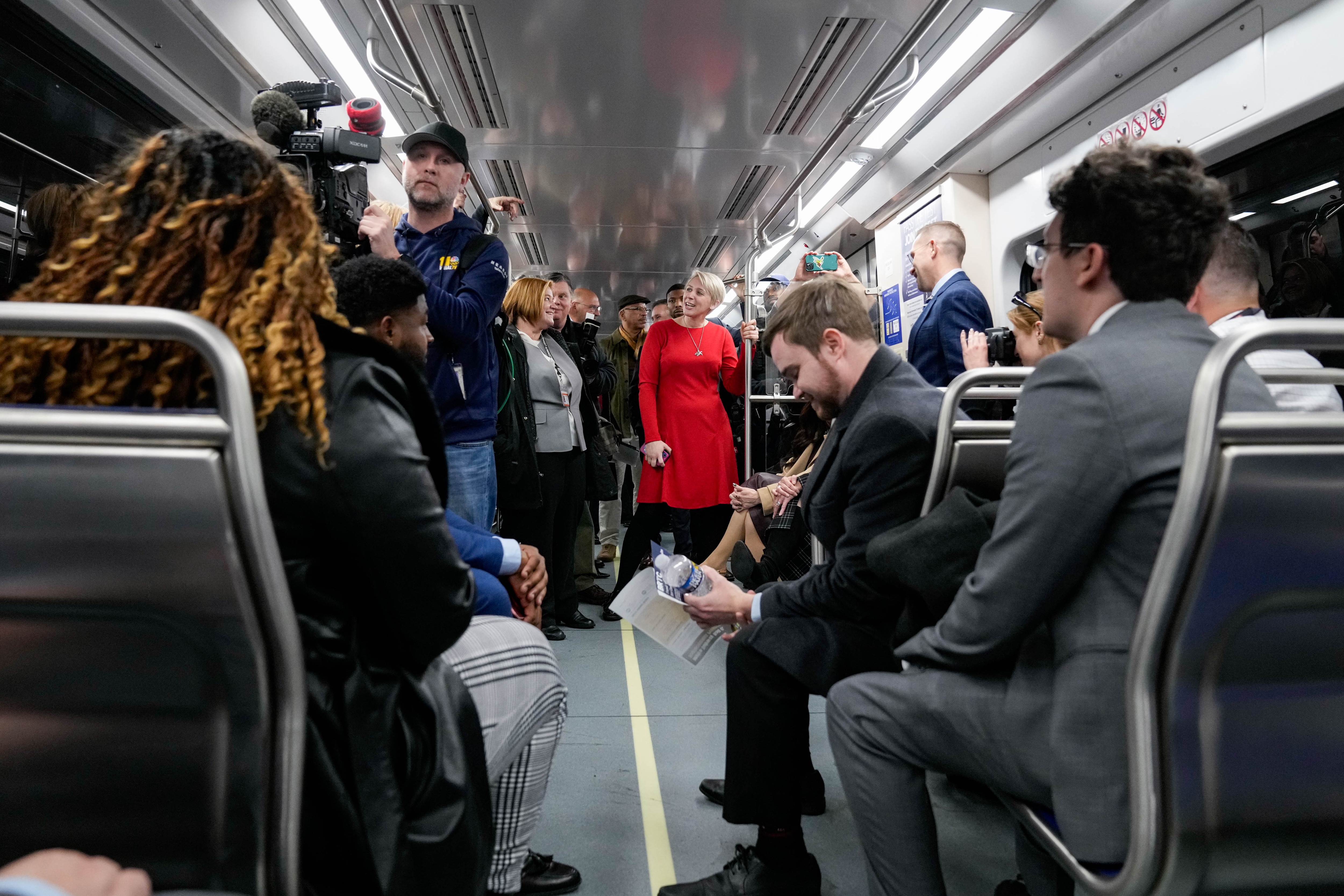 Maryland Transit Administrator Holly Arnold, center, joins media and other officials on one of the new train cars on its inaugural journey with passengers through the Metro SubwayLink system Wednesday.