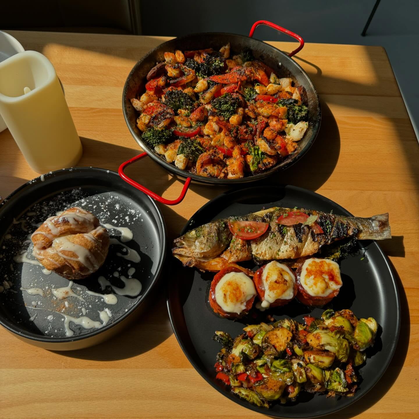 Whole grilled Bronzino, crème brûlée yams, house made sweet rolls/w honeycomb butter, seafood paella, and marinated brussels sprouts from Shareef's Grill.