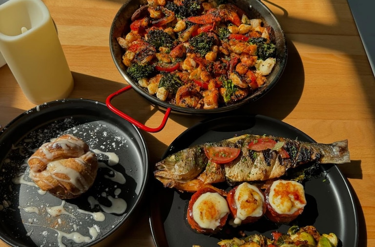 Whole grilled Bronzino, crème brûlée yams, house made sweet rolls/w honeycomb butter, seafood paella, and marinated brussels sprouts from Shareef's Grill.