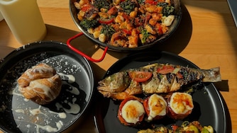 Whole grilled Bronzino, crème brûlée yams, house made sweet rolls/w honeycomb butter, seafood paella, and marinated brussels sprouts from Shareef's Grill.