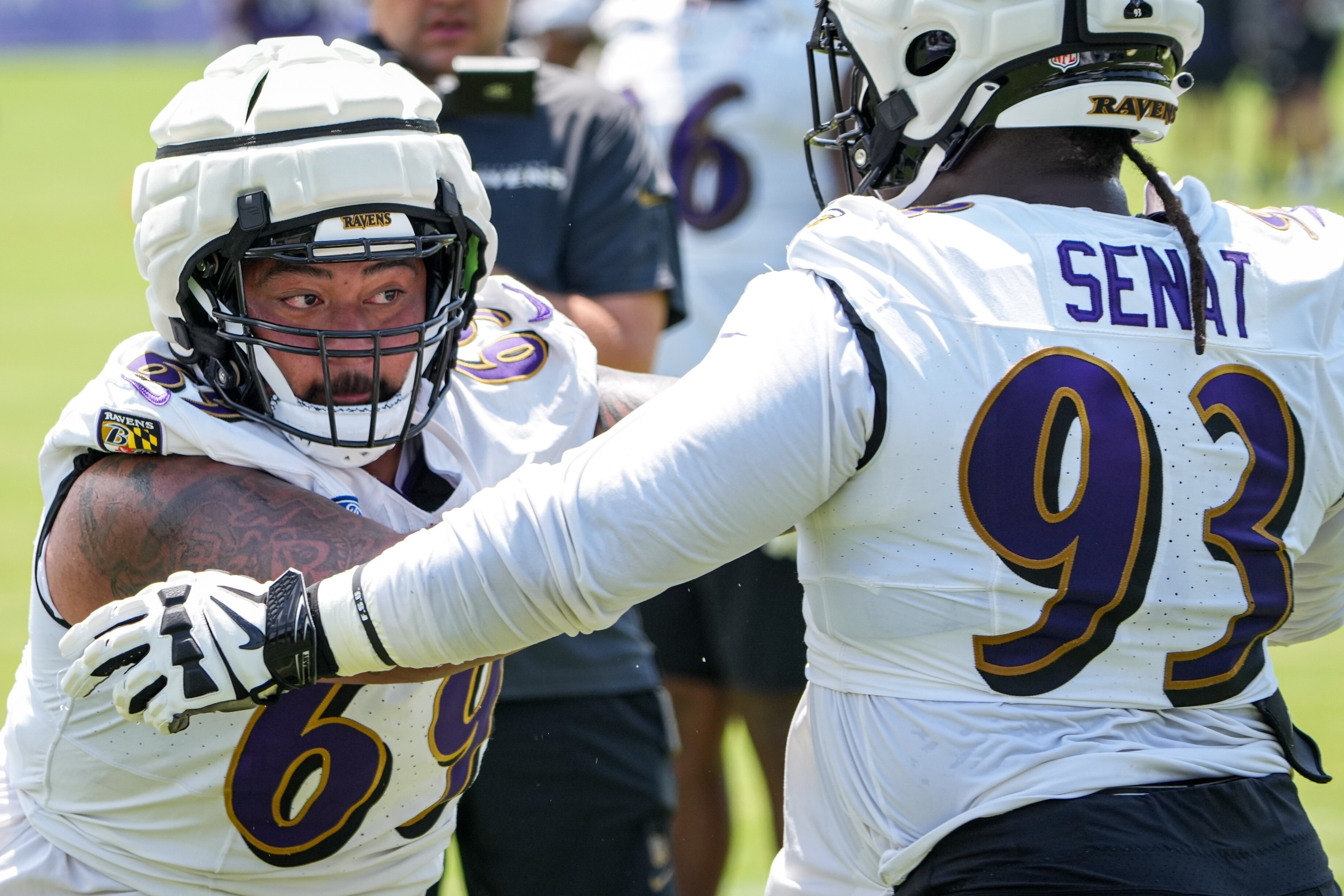 Defensive tackle Josh Topou (left) and nose tackle Deadrin Senat participate in a drill at Ravens training camp Wednesday. (Ulysses Muñoz/The Baltimore Banner)