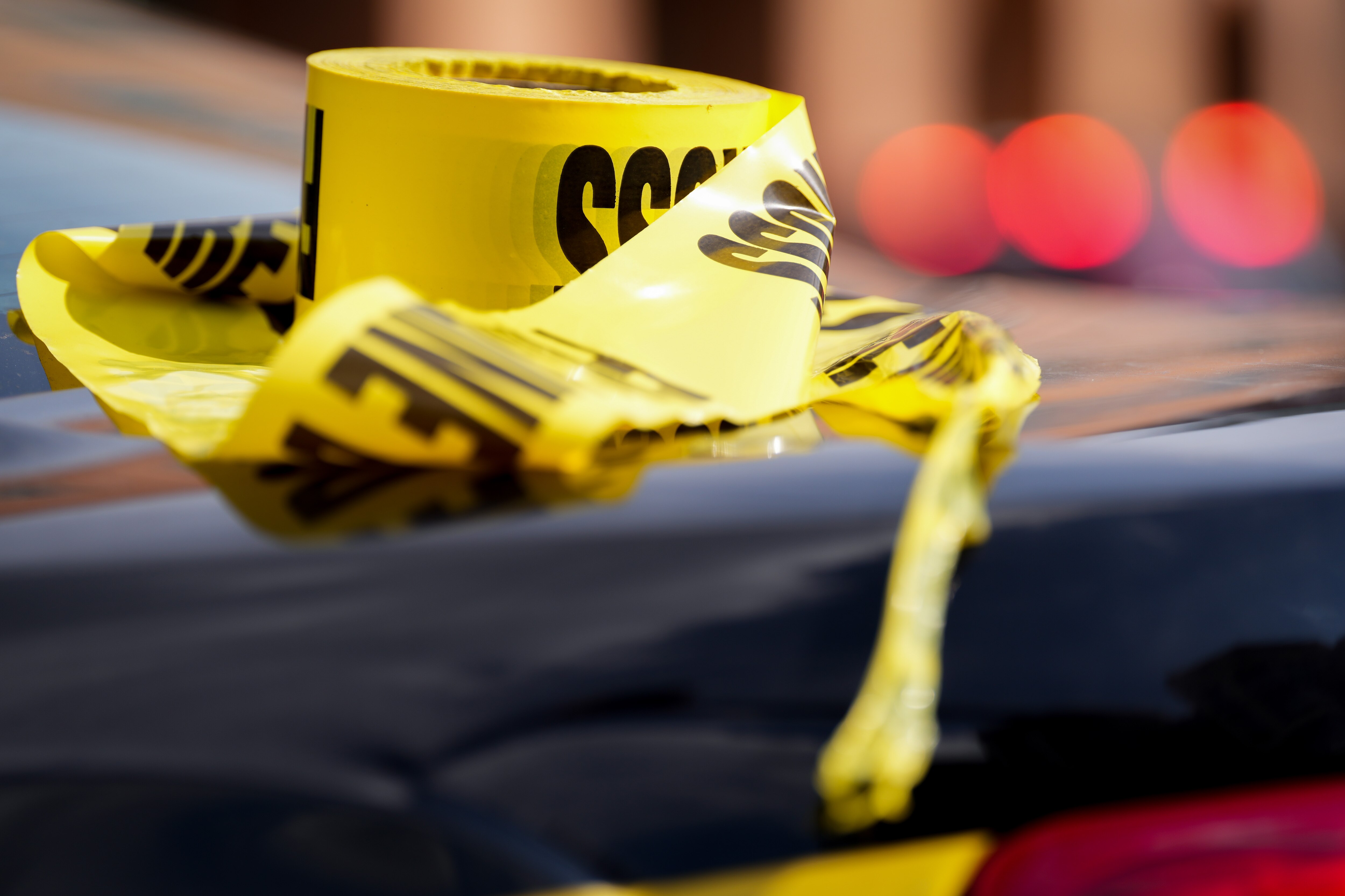 Baltimore Police crime scene tape sits unused on a police vehicle at the scene after a vehicle exploded inside a five-story parking garage in Baltimore’s Fells Point neighborhood on 7/27/22.  Two people are being treated for injuries, fire officials said Wednesday afternoon.
