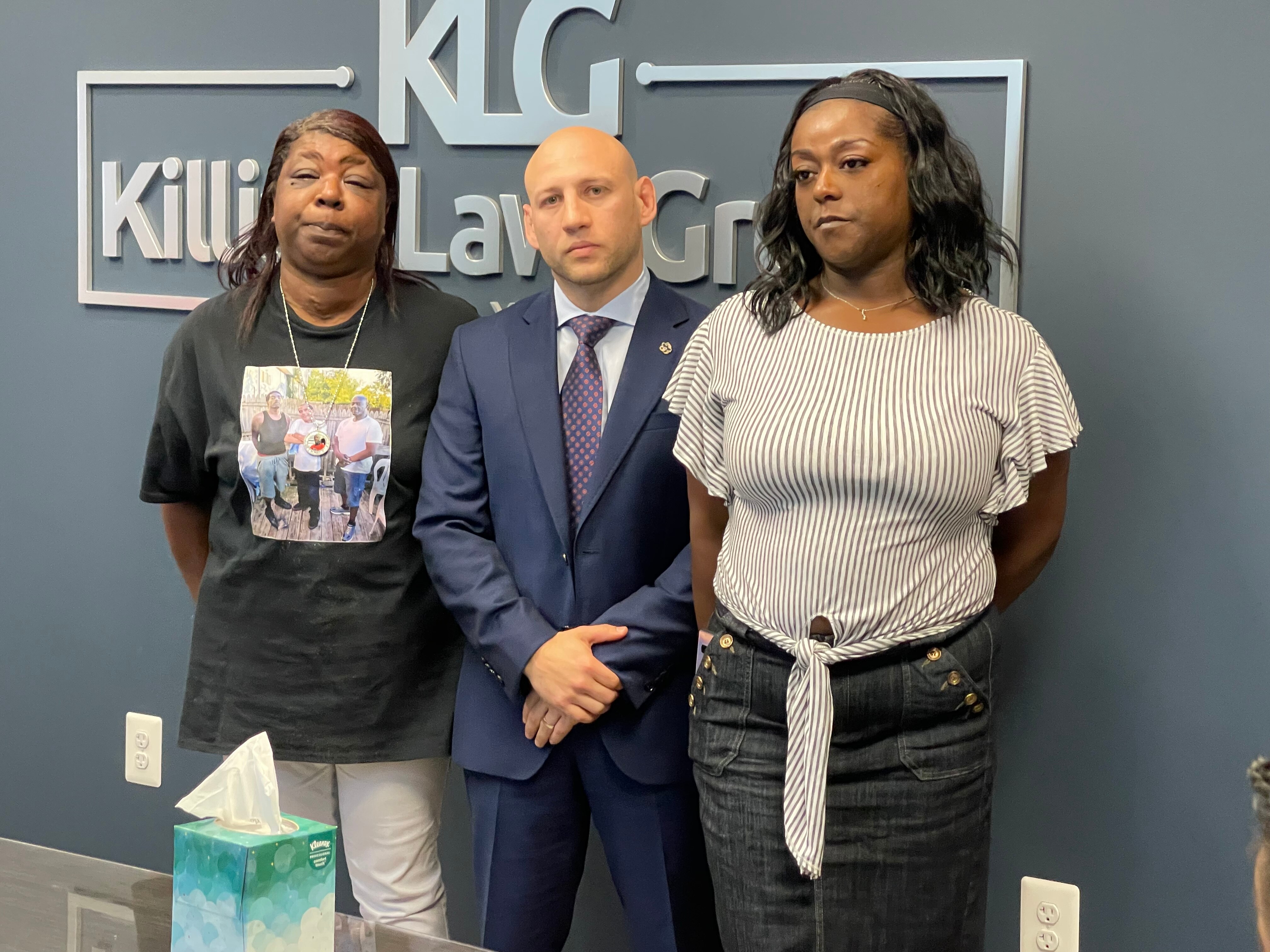 Vernia Lee Harrell, left, stands with Candice Holden, right, and their attorney Alex Binder following a news conference about the death of Terry Harrell, a 58-year old man who was killed by Baltimore Police Officer Alexis Acosta while Harrell was riding his scooter through a green light at an intersection in the East Broadway area.