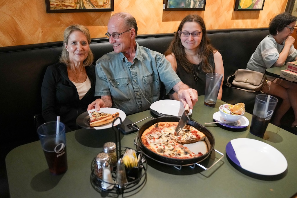 Customers Lisa, left, David and Kelsey Charconas discuss their memories of ordering from Armand's Pizzeria & Grille in Rockville, Md. on Wednesday, June 17, 2026. After more than 50 years in business, the pizza shop will close its doors this week.