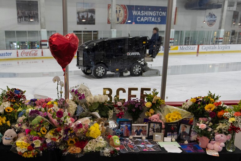 An ice resurfacer prepares the ice as a memorial is seen along the boards at MedStar Capitals Iceplex Sunday, Feb. 2, 2025, in Arlington, Va., for the figure skaters who were among the 67 victims of a mid-air collision between an Army helicopter and an American Airlines flight from Kansas. (AP Photo/Carolyn Kaster)