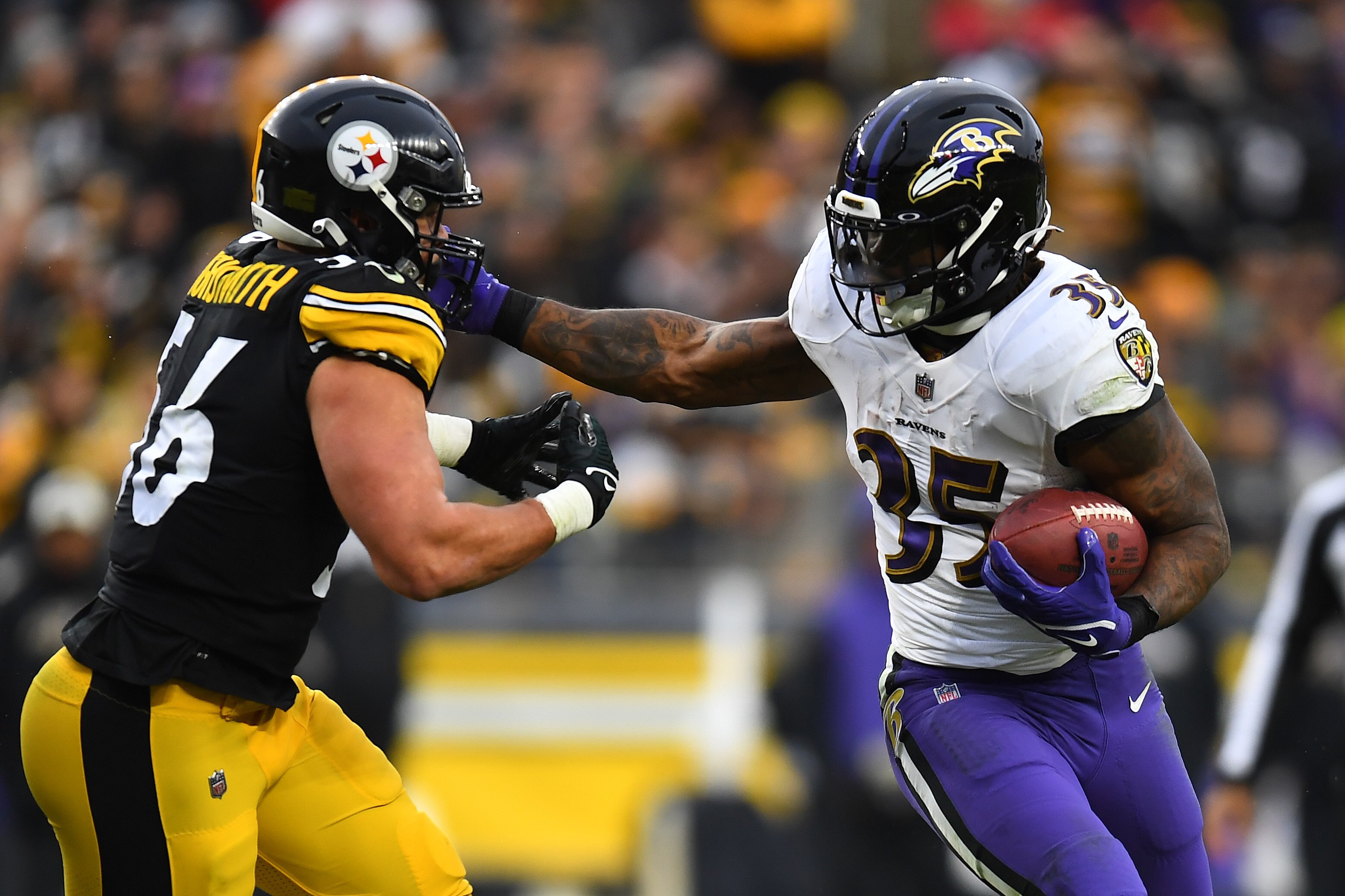 PITTSBURGH, PENNSYLVANIA - DECEMBER 11: Gus Edwards #35 of the Baltimore Ravens runs with the ball as Alex Highsmith #56 of the Pittsburgh Steelers attempts the tackle during the third quarter of the game at Acrisure Stadium on December 11, 2022 in Pittsburgh, Pennsylvania. (Photo by Joe Sargent/Getty Images)