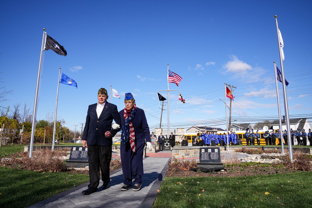 VVA Chapter 965 President Bob Sandlass and VWF Auxiliary 2678 President Linda Henderson return to their seats after unveiling the monuments to Battle of North Point Sharpshooters at Veterans Memorial Park, just outside of Wells-McComas VFW Post 2678, during a Veterans Day observance ceremony in Sparrows Point, Md., on Tuesday, November 11, 2025.