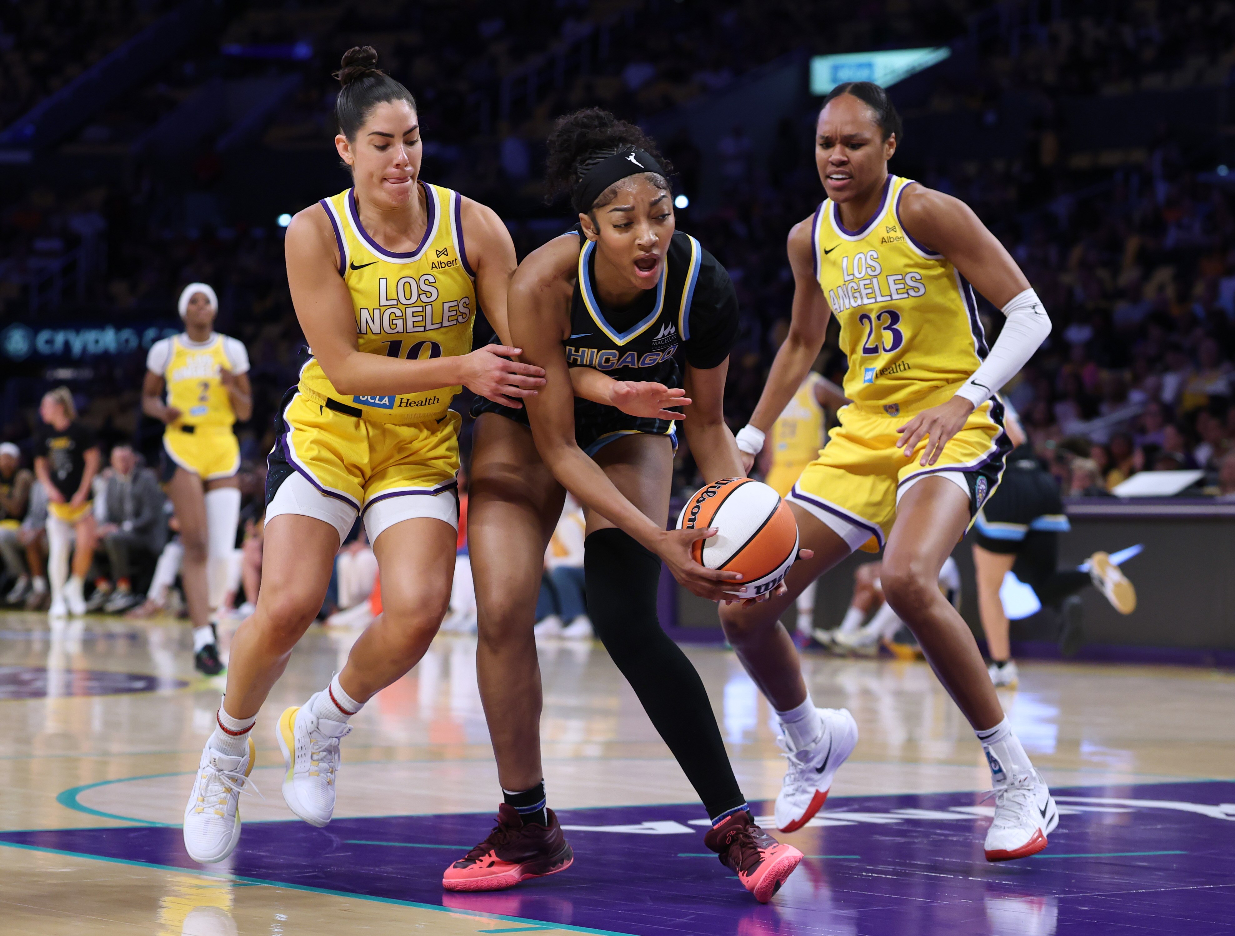 Angel Reese of the Chicago Sky grabs the ball between two Sparks players Sunday in Los Angeles.