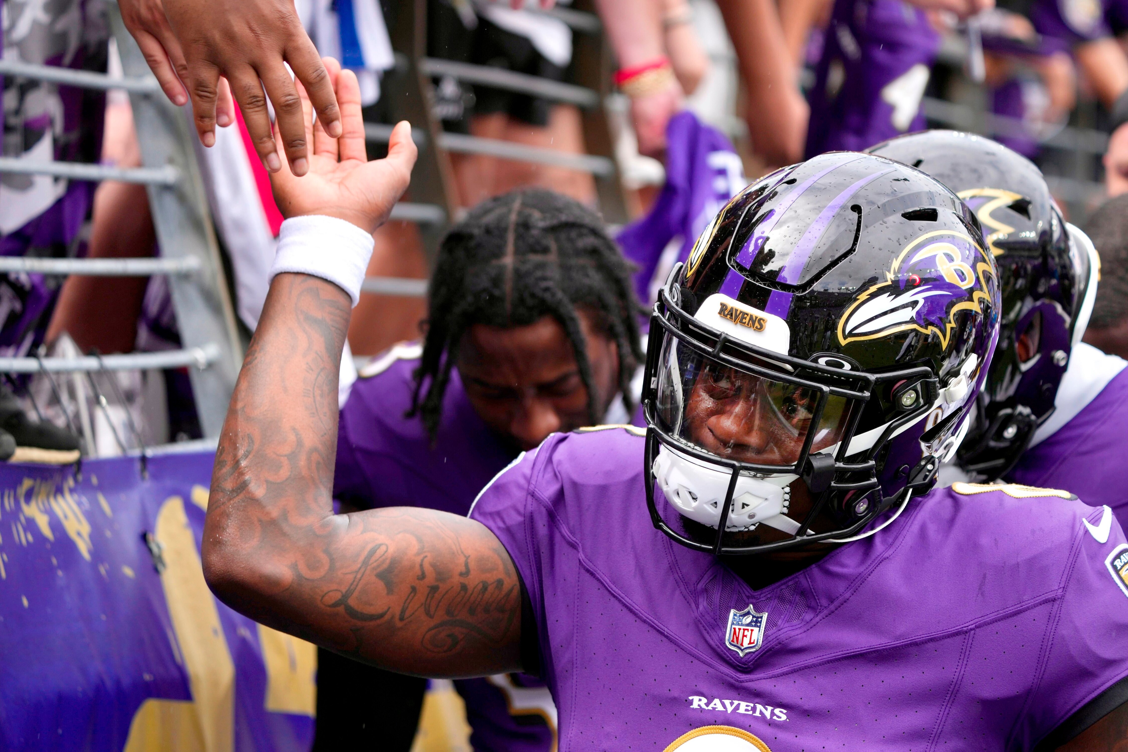Ravens quarterback Lamar Jackson slaps hands with fans at M&T Bank Stadium before the Ravens face the Texans in the season opener against the Houston Texans.