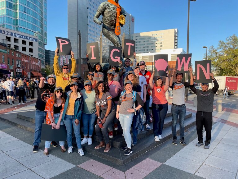 A Citizens of Pigtown group poses outside of Camden Yards during a recent home game. Some residents hold signage that spells out 'Pigtown.' Citizens of Pigtown is a neighborhood association that represents residents and businesses.