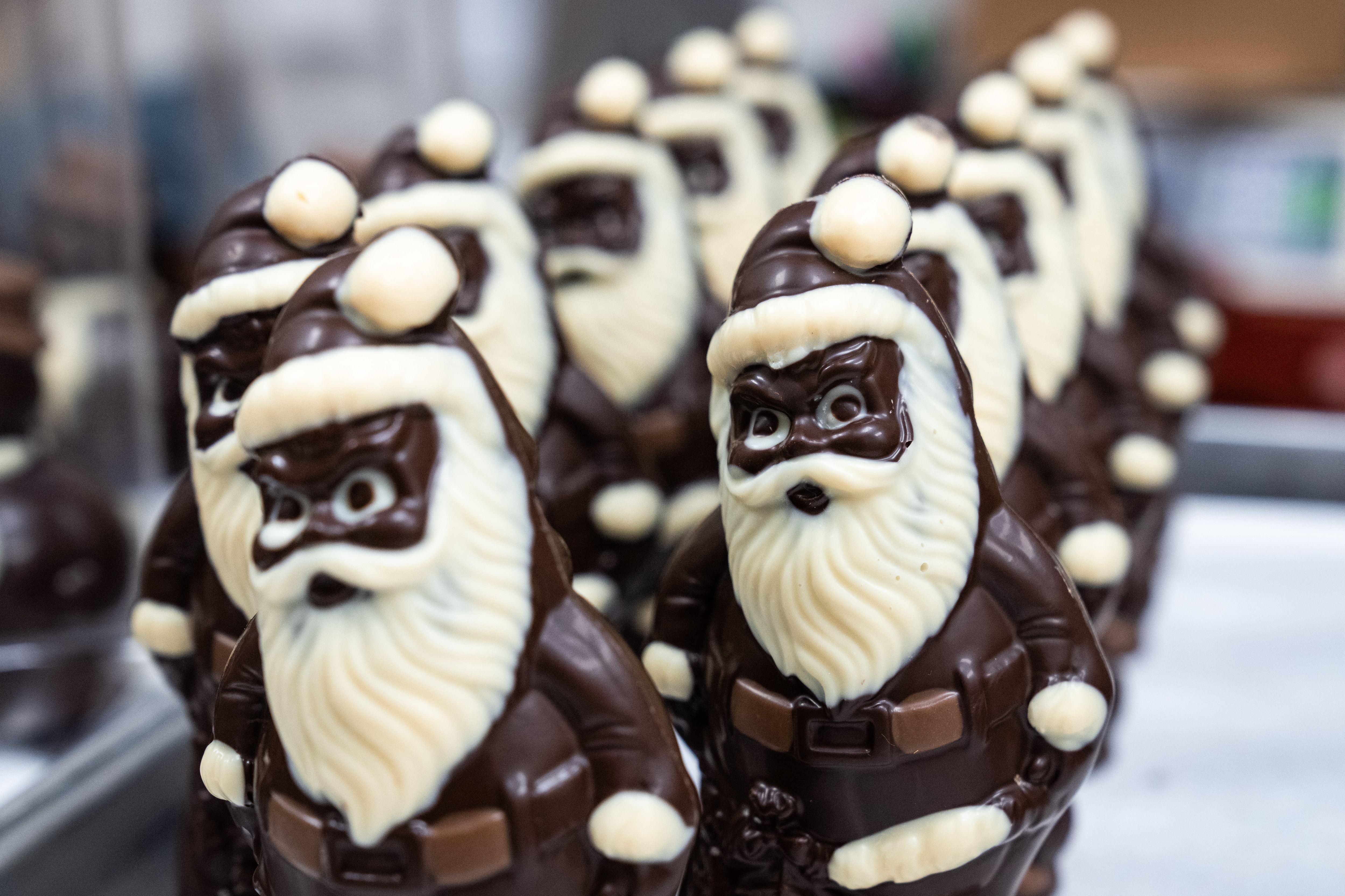 Dark chocolate Santas line up on a tray.