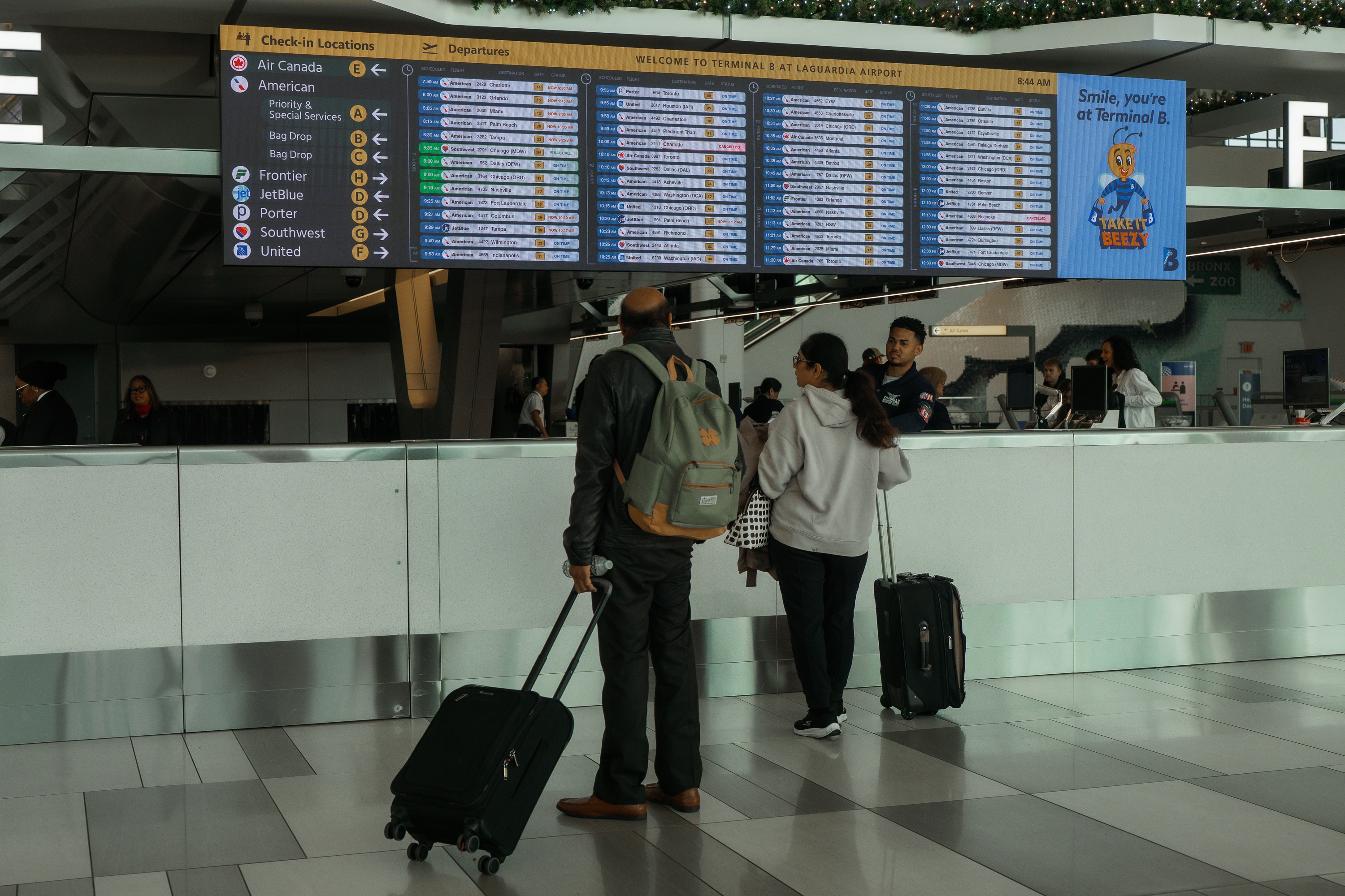 Travelers check the flight schedule at LaGuardia International Airport on Saturday, Nov. 8, 2025, in New York. (AP Photo/Olga Fedorova)