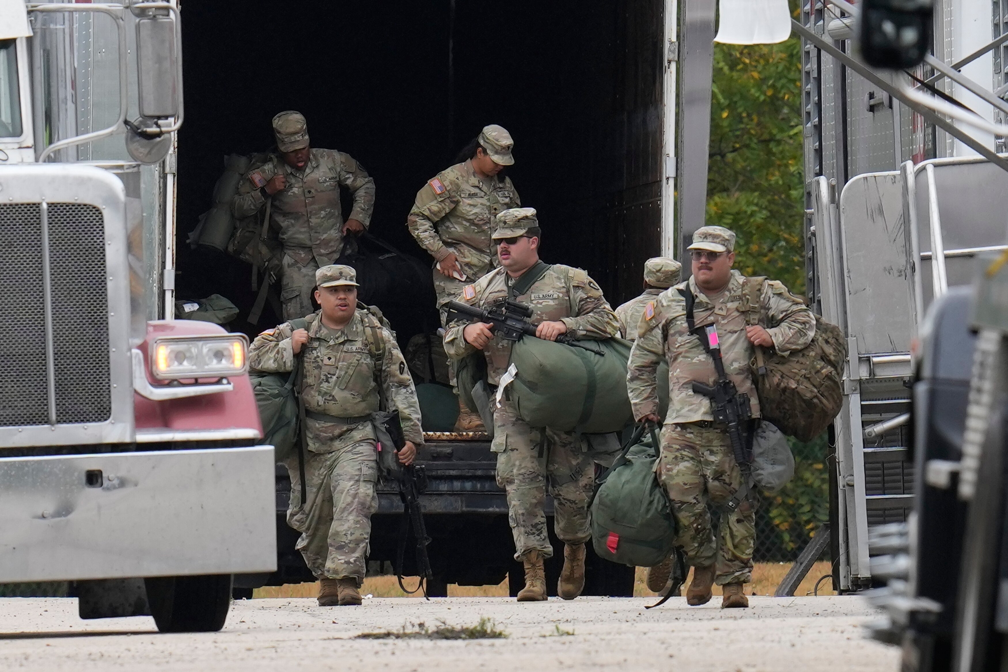 Military personnel in uniform, with the Texas National Guard patch on, are seen at the U.S. Army Reserve Center, Tuesday, Oct. 7, 2025, in Elwood, Ill., a suburb of Chicago.