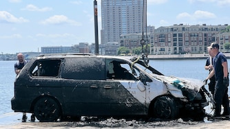 Baltimore City Fire and the Baltimore City Police Underwater Recovery Team work to pull a Silver Cab from the Inner Harbor on Thursday, July 24, 2025.