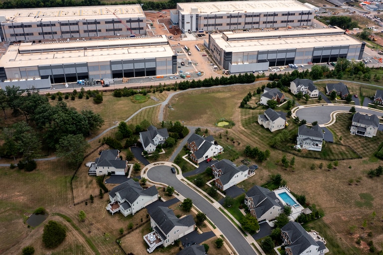 STONE RIDGE, VIRGINIA - JULY 17: In an aerial view, an Amazon Web Services data center is shown situated near single-family homes on July 17, 2024 in Stone Ridge, Virginia. Northern Virginia is the largest data center market in the world, according to a report this year cited in published accounts, but is facing headwinds from availability of land and electric power.