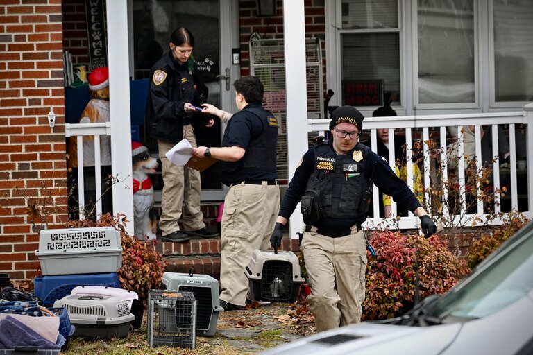 FEBRUARY 20, 2026 - Baltimore County Department of Health animal services division officers carry large dogs from a home in Halethorpe.