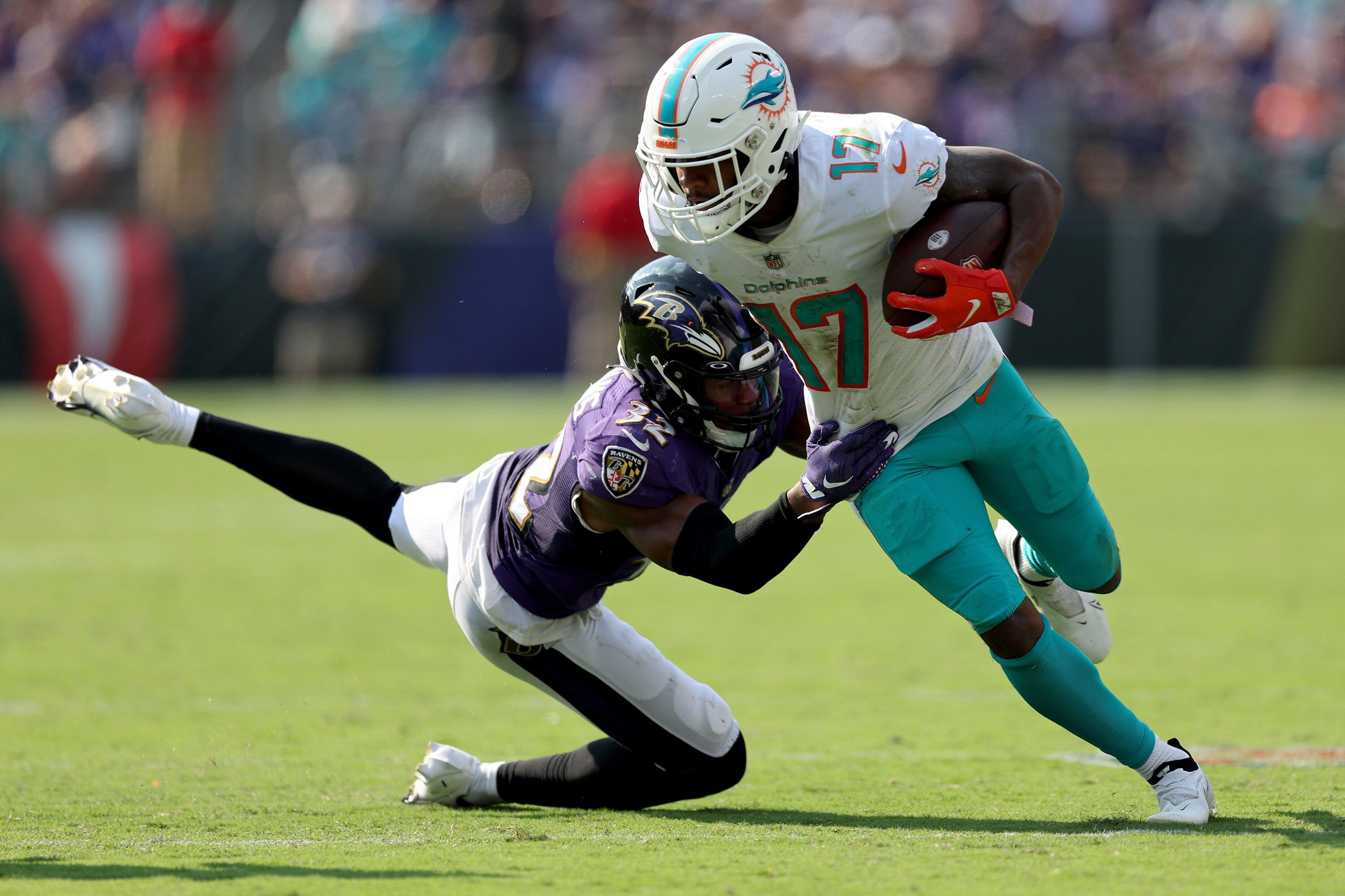 BALTIMORE, MARYLAND - SEPTEMBER 18: Jaylen Waddle #17 of the Miami Dolphins carries the ball against Marcus Williams #32 of the Baltimore Ravens in the second half at M&T Bank Stadium on September 18, 2022 in Baltimore, Maryland.