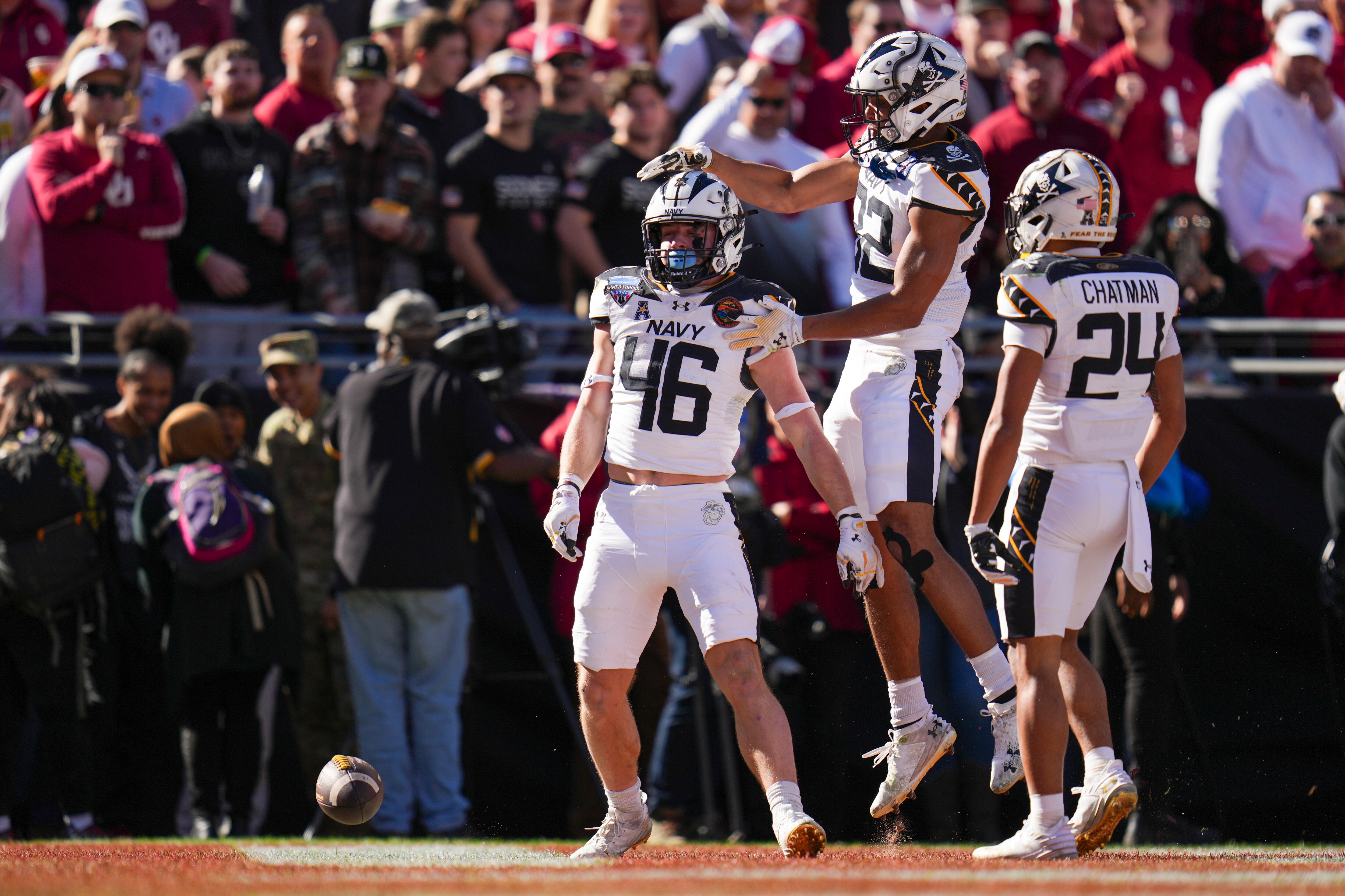 Navy fullback Alex Tecza, (46) celebrates his touchdown run with running backs Eli Heidenreich (22) and Brandon Chatman (24) during the first half of the Armed Forces Bowl NCAA college football game against Oklahoma, Friday, Dec. 27, 2024, in Fort Worth, Texas.