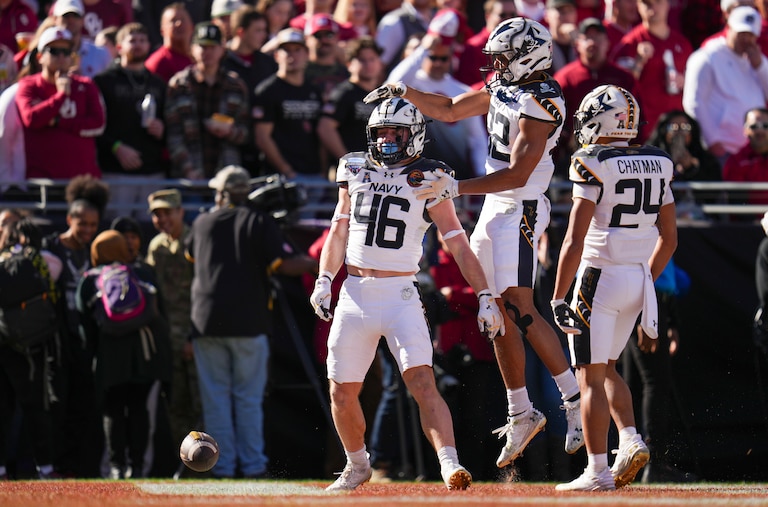 Navy fullback Alex Tecza, (46) celebrates his touchdown run with running backs Eli Heidenreich (22) and Brandon Chatman (24) during the first half of the Armed Forces Bowl NCAA college football game against Oklahoma, Friday, Dec. 27, 2024, in Fort Worth, Texas.