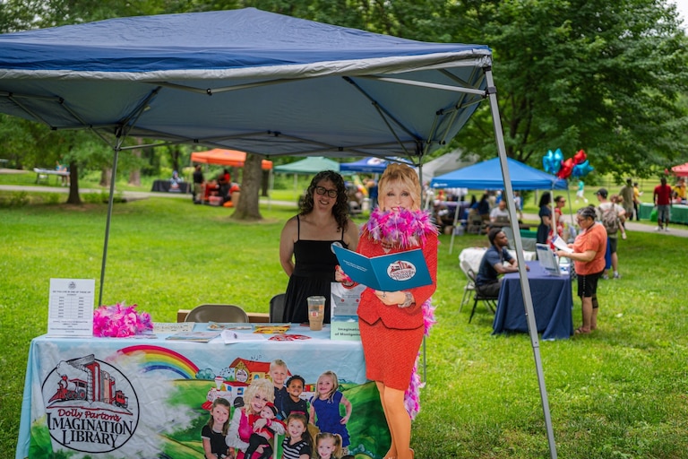 Imagination Library of Montgomery County, Maryland, Program Director Carol da Silva poses with a life-size cardboard cutout of Dolly Parton while promoting the program at a recent Father’s Day event in Wheaton.