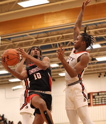 Edmondson's Deonte Green (left) heads to the basket as City's Cam Horton defends during Thursday's Baltimore City boys basketball match. Horton had 20 points and 11 rebounds as the fourth-ranked Knights remained undefeated with a 78-73 victory over No. 6 Edmondson in North Baltimore.