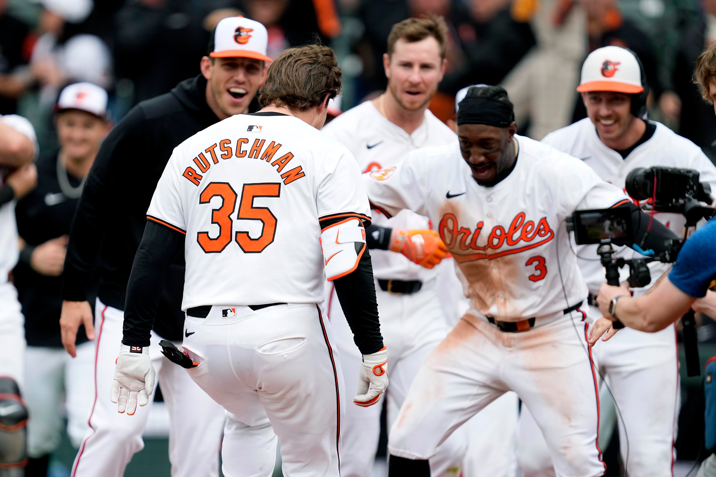 Orioles teammates greet Adley Rutschman at home plate after his two-run, walk-off home run Wednesday lifted the team over Toronto 3-2.