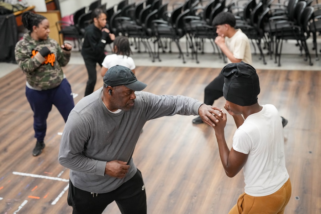 Coach Earl Hellem, front left, teaches a young student boxing technique at the Mack Lewis Boxing Gym in Baltimore, Md. on Tuesday, April 14, 2026.