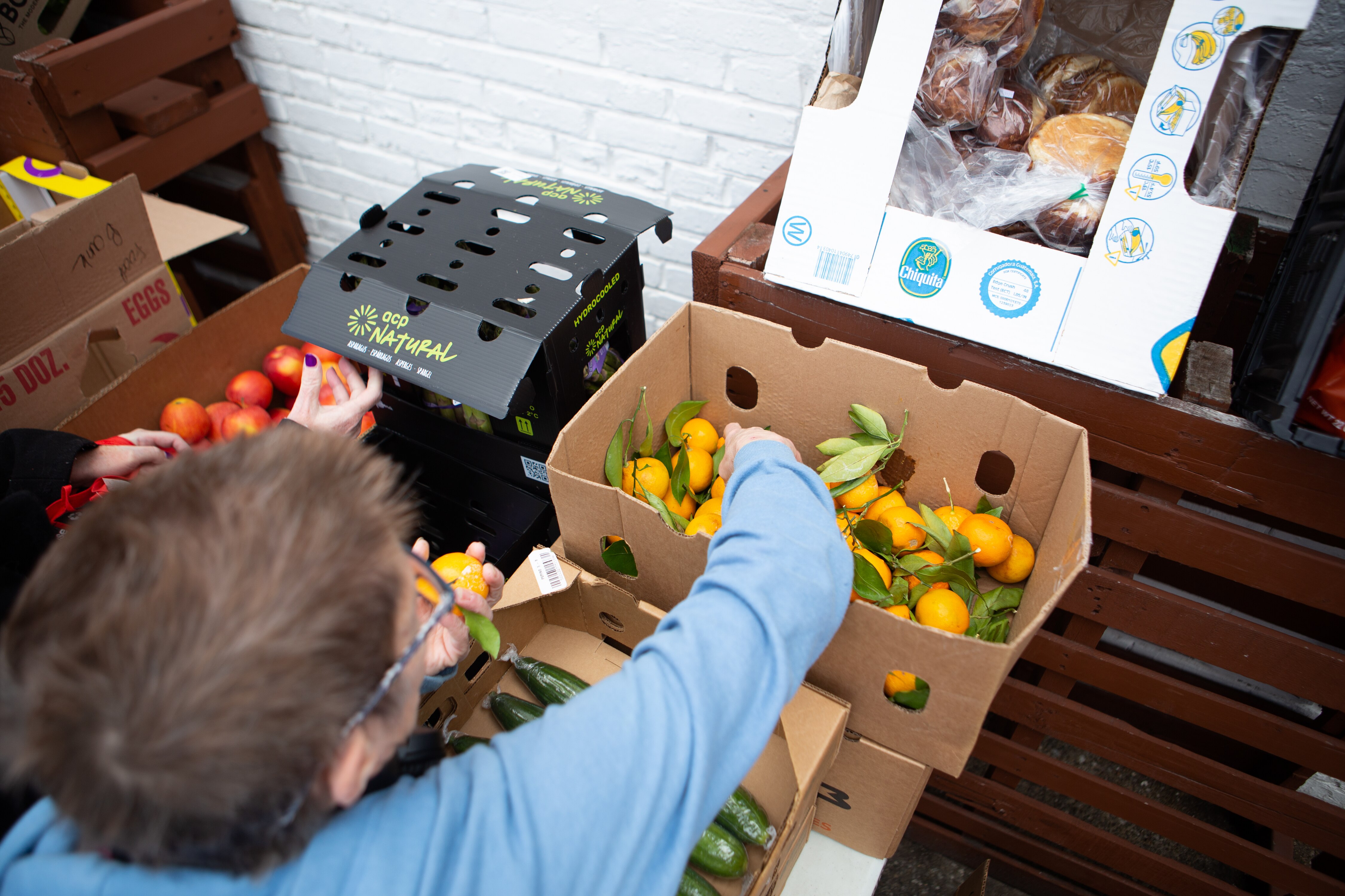 Karen Taylor, a resident of Union Square in South Baltimore, attends a food giveaway outside of Old Major bar in Pigtown on Thursday, January 5. She relied on PriceRite for the majority of her groceries. Since the store's closure, she now travels a mile by foot or bus to Food Depot at the Westside Shopping Center, where she says prices are much higher.