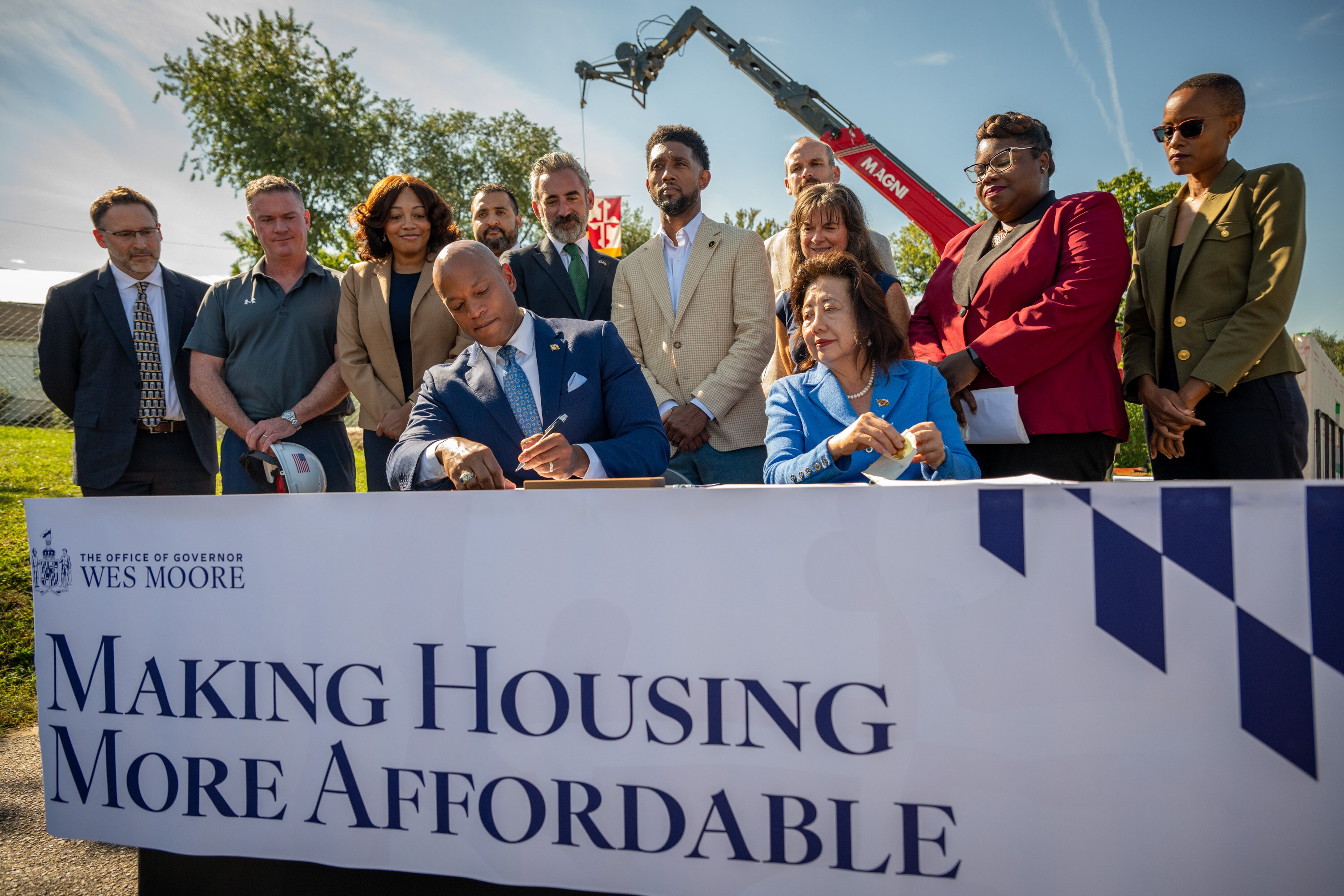 Gov. Wes Moore signs one of two executive orders focused on lowering housing costs on the site of a modular home being built in Brooklyn on Thursday.