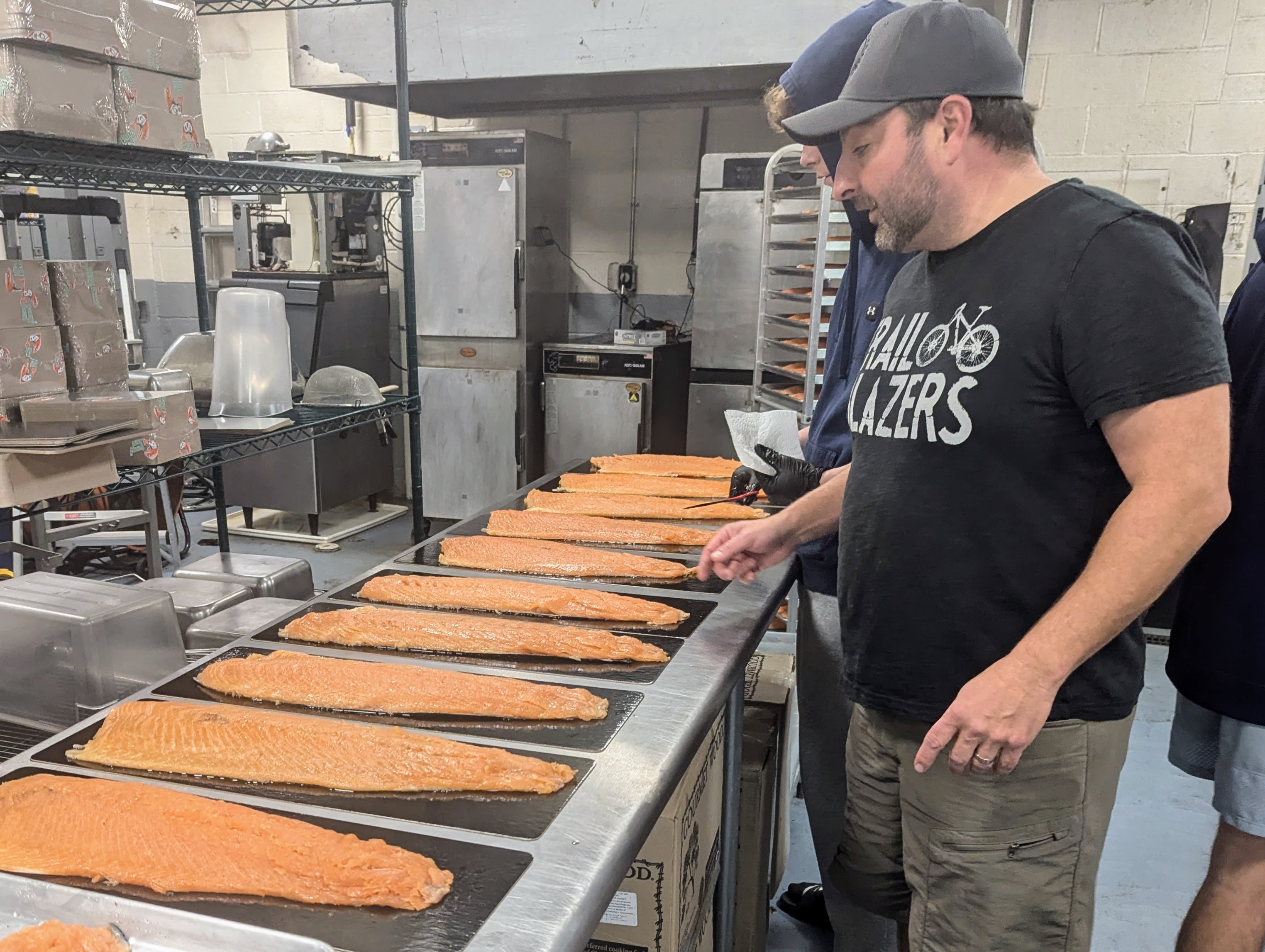 Rock Zang, owner of Chesapeake Smokehouse in Annapolis, looks over a row of smoked salmon fillets ready for packaging on Nov. 25, 2024.