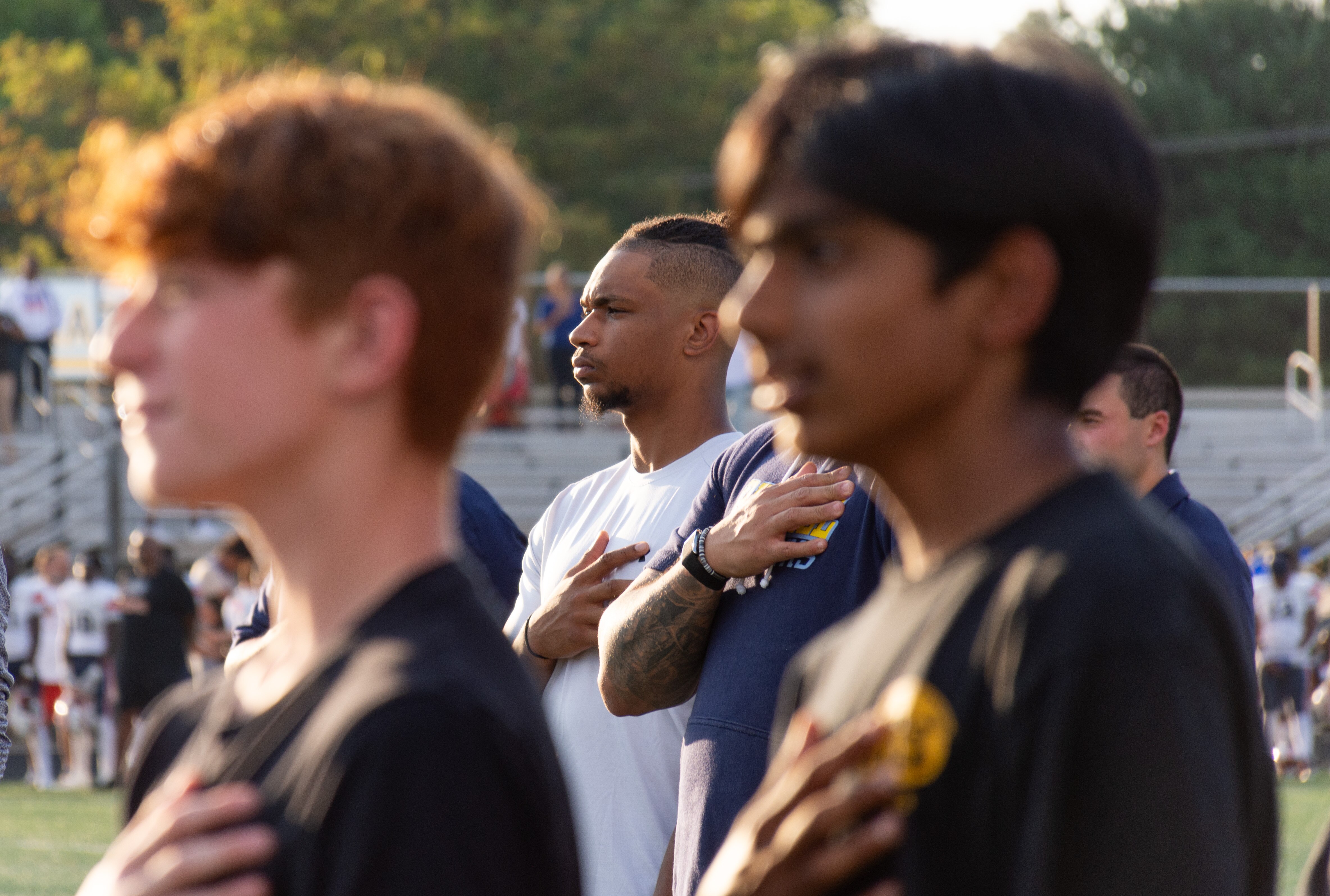Ravens safety Beau Brade, center, stands for the national anthem ahead of River Hill's game against Reservoir on September 20, 2024.