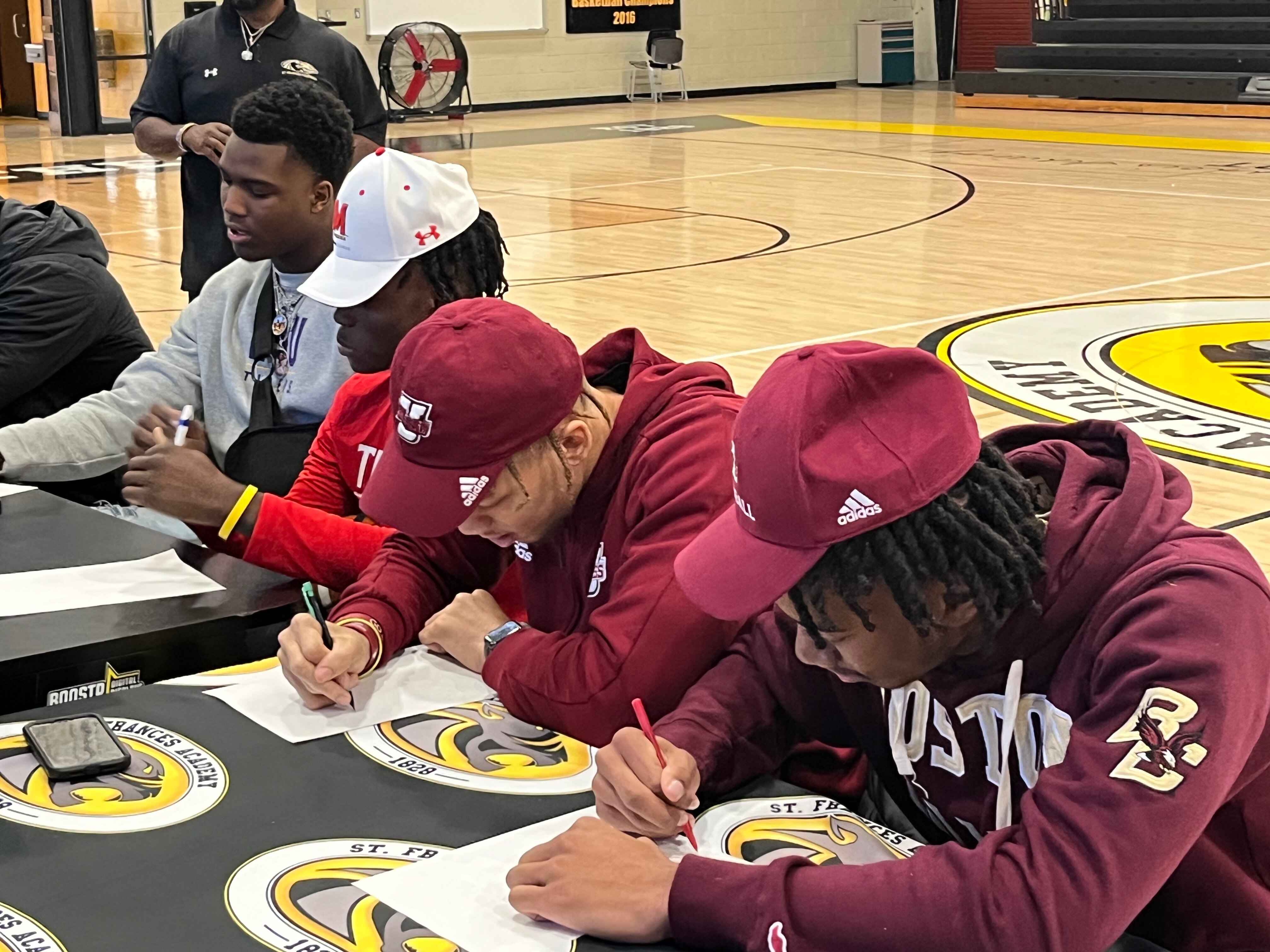 Da'Shawn Womack (left), Ryan Manning, Donovan Dyson and K.P. Price sign scholarship letters during a ceremony inside St. Frances' gym Wednesday afternoon. Womack signed with LSU with Manning headed to Maryland, Dyson to UMASS and Price to Boston College.
