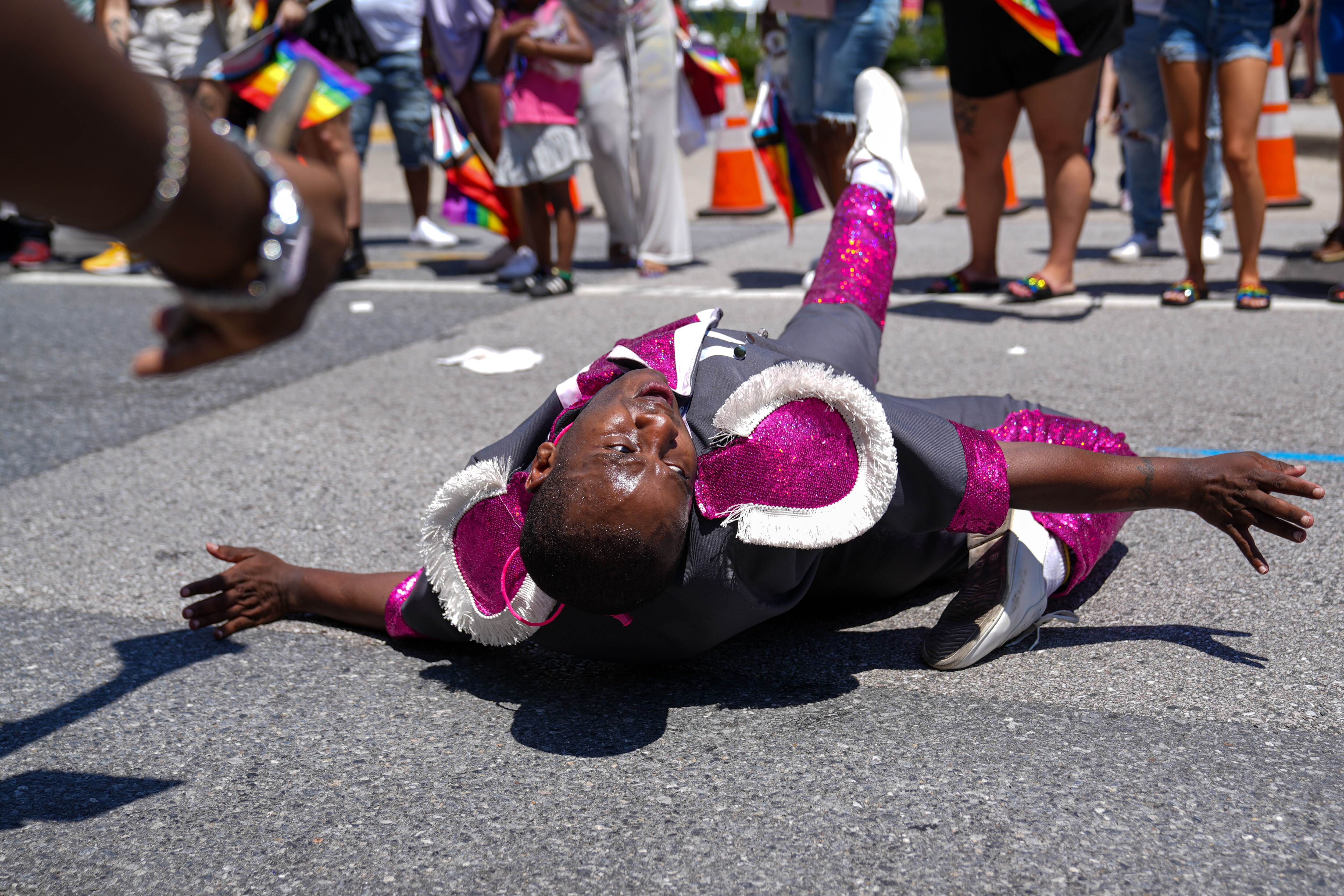 6/25/22—A bandleader with the Extravaganza Marching Unit dances on the ground march during the Baltimore Pride Parade on Charles St.