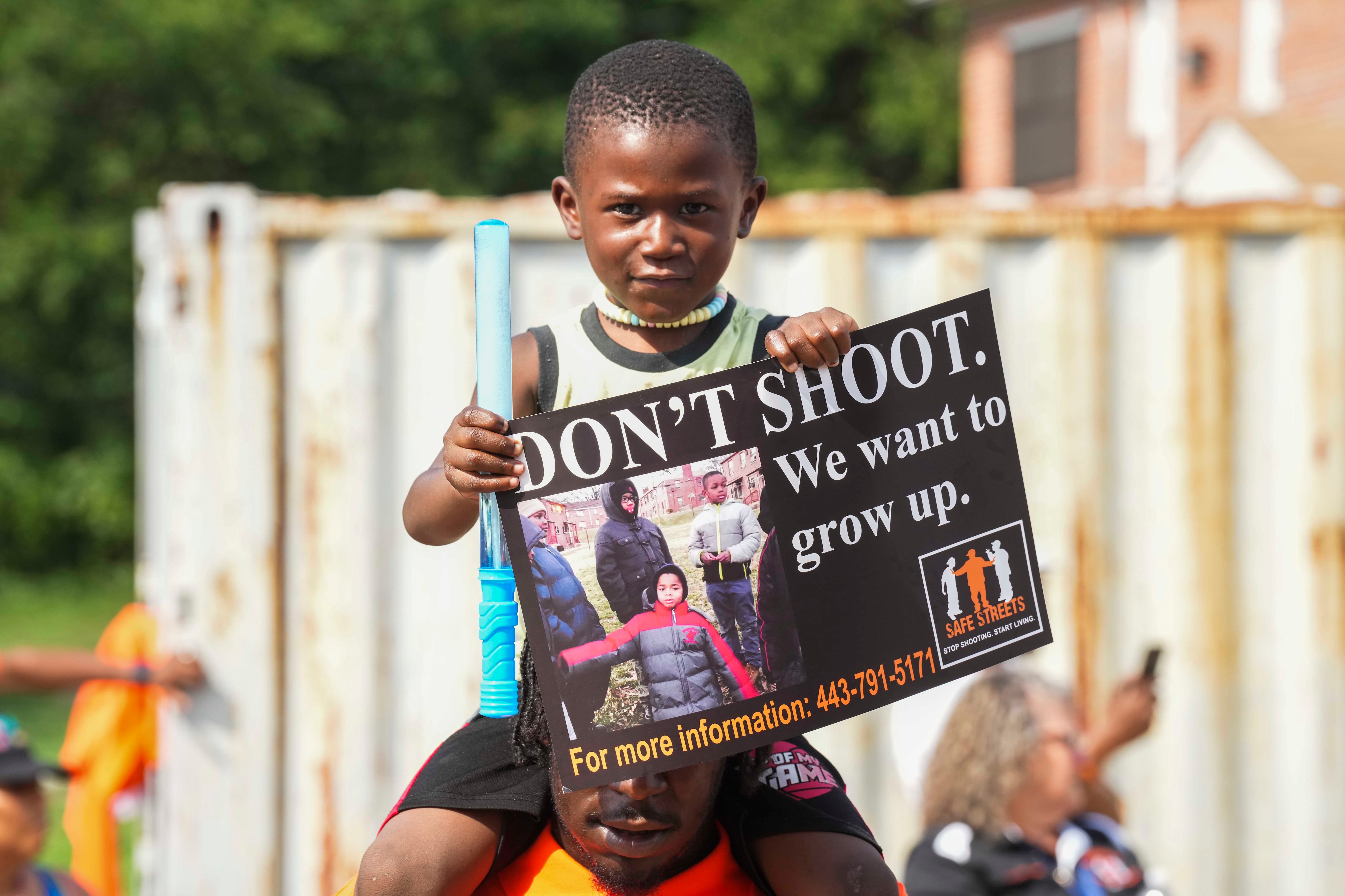 Children hold up signs during a Safe Streets peace walk in Brooklyn, days after two people were killed and 28 others were injured in a mass shooting.