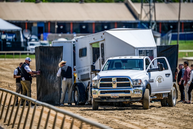 An equine ambulance works on the dirt track after a horse suddenly collapsed after the first race of Preakness Friday ahead of the Black-Eyed Susan Stakes at Laurel Park racetrack.