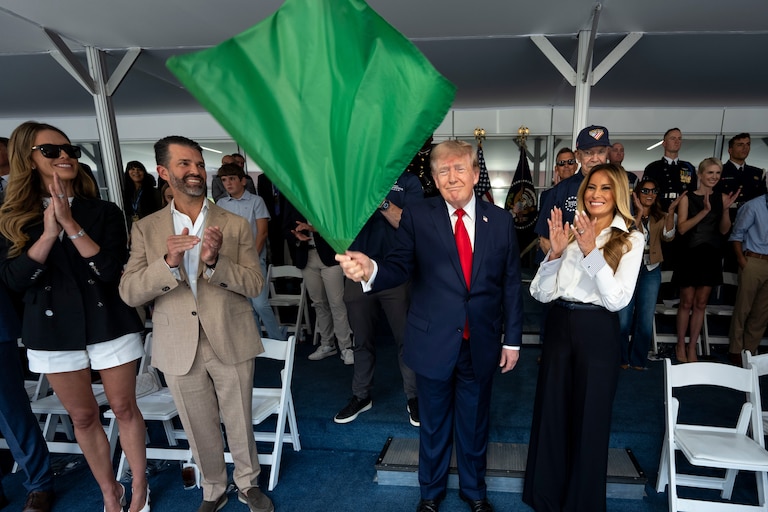 President Donald Trump waves the green flag to start the race alongside first lady Melania Trump, right, and from left, Bettina Trump and Donald Trump Jr. during the IndyCar Freedom 250 Grand Prix auto race, Sunday, Aug. 23, 2026, in Washington. (Doug Mills/The New York Times via AP, Pool)